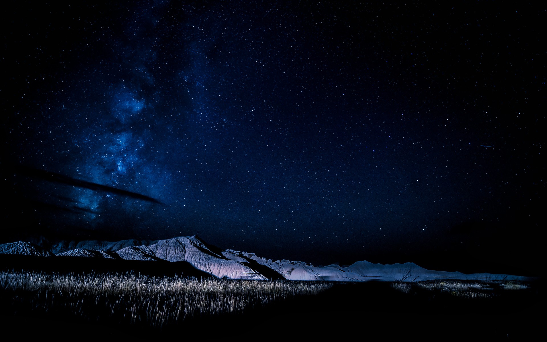 Night sky over mountains and grass HD Wallpaper