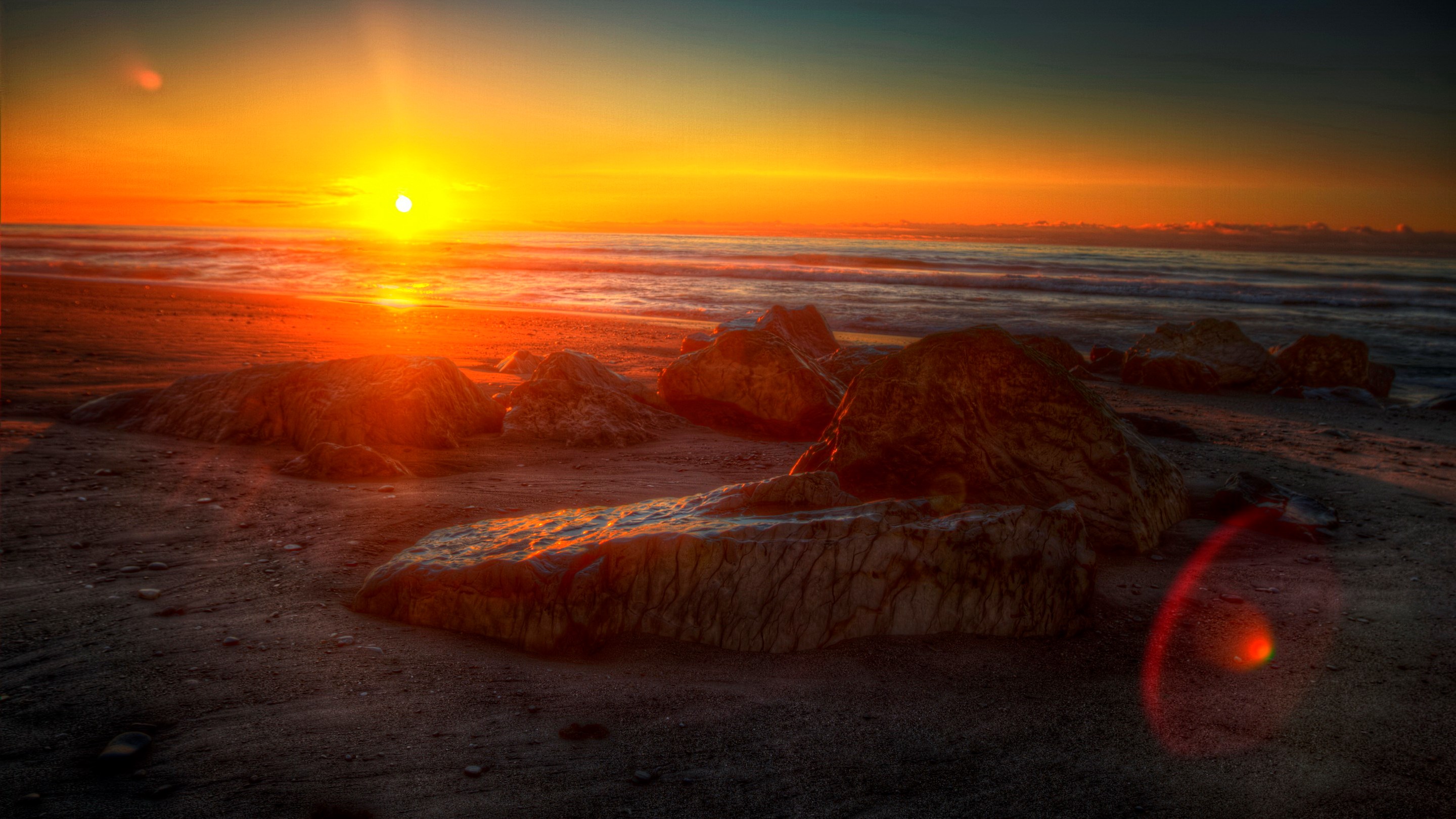 Sunset over a rocky beach with ocean waves HD Wallpaper