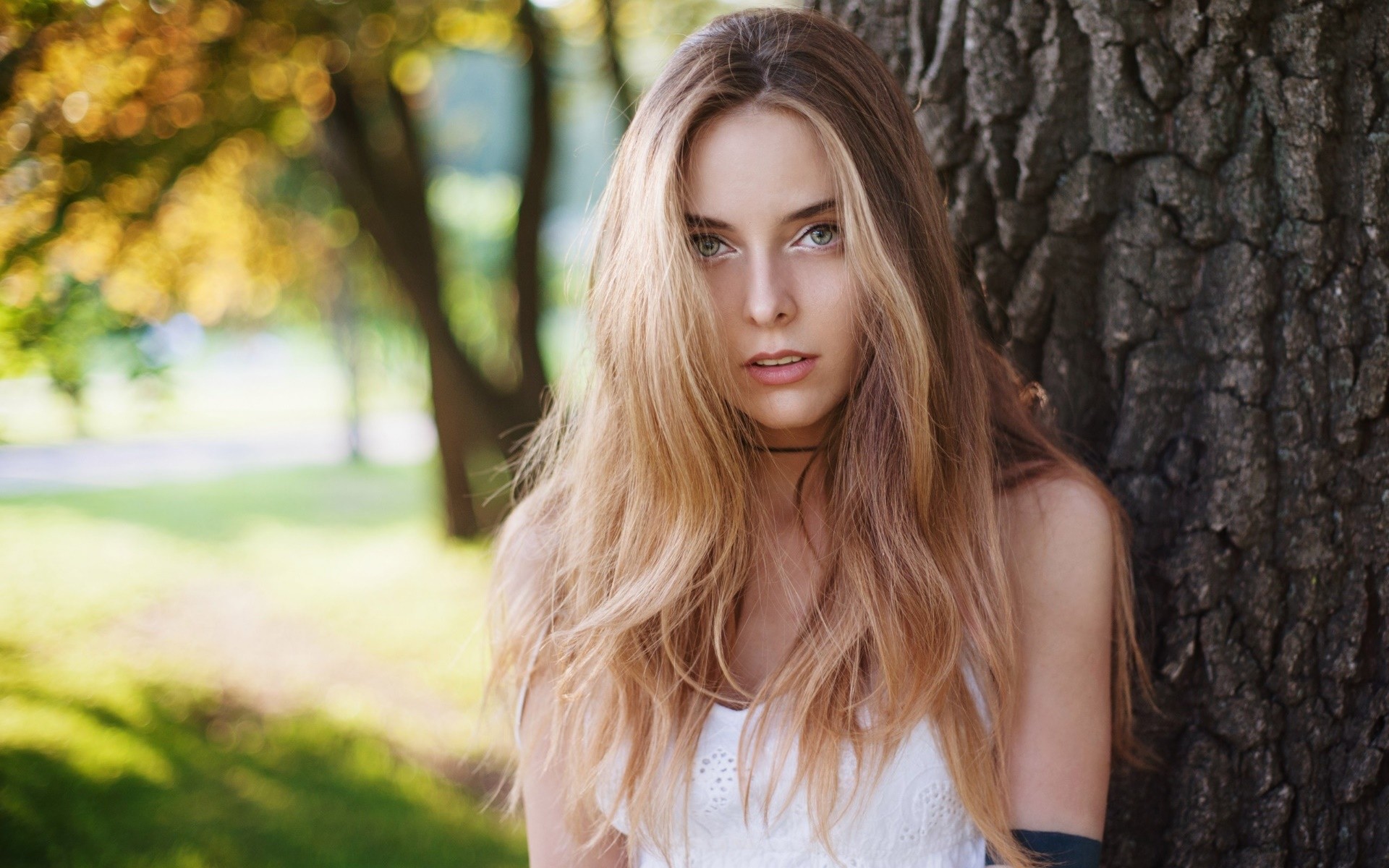 Woman with blonde hair leaning against a tree HD Wallpaper
