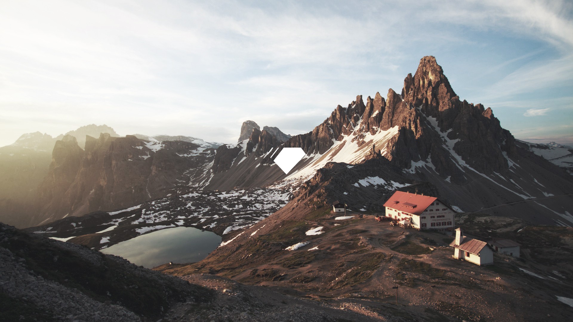 Mountain range with a lake and buildings HD Wallpaper