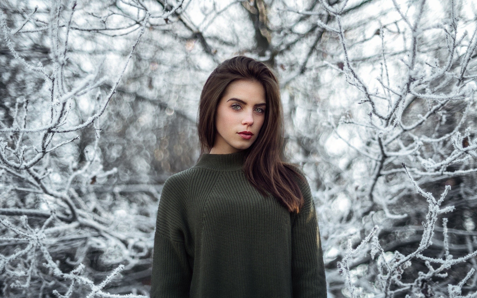Woman in a green sweater in a winter forest HD Wallpaper