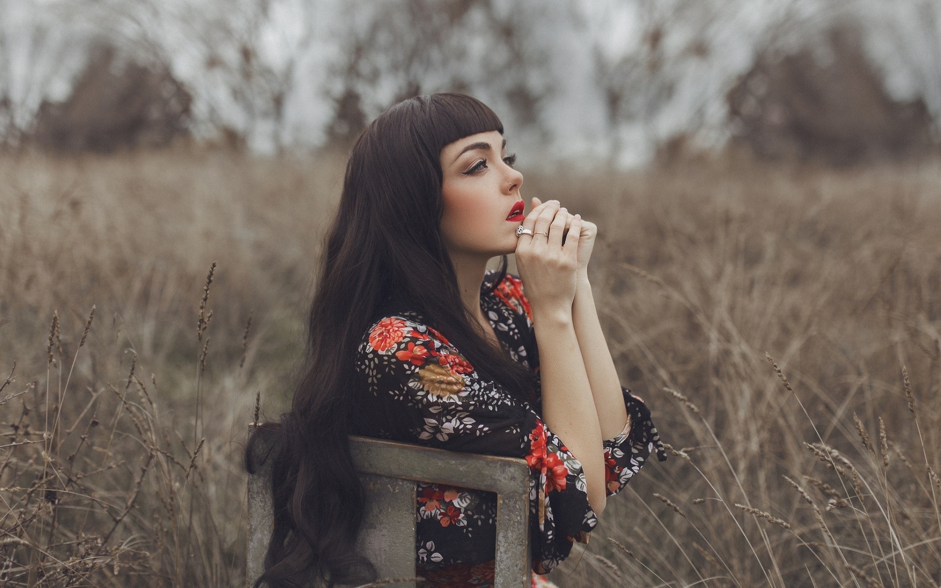 Woman with long dark hair sitting outdoors HD Wallpaper