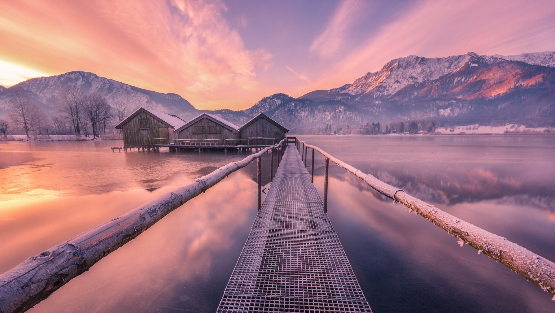 Winter landscape with boathouses on a frozen lake at sunrise HD Wallpaper