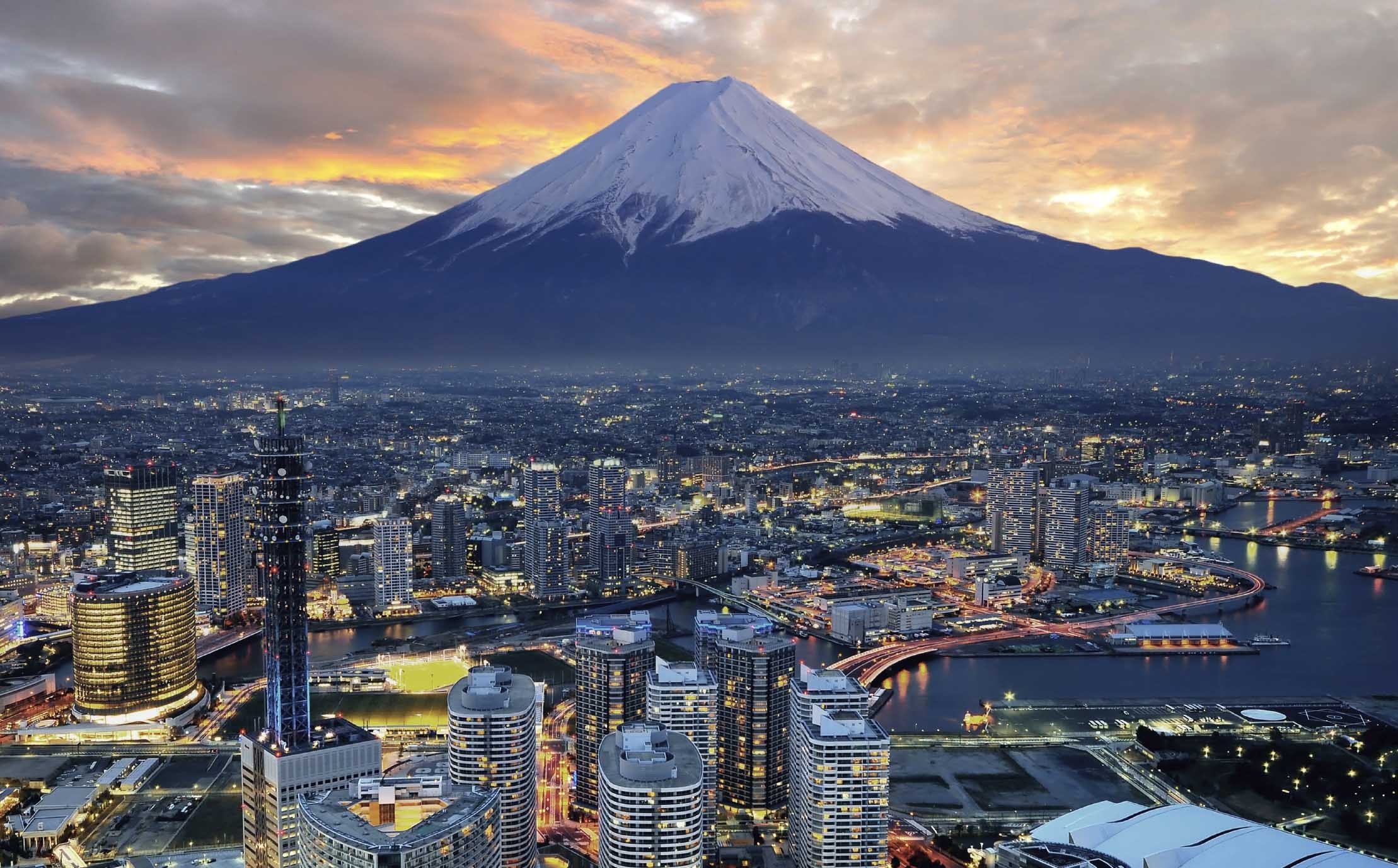Mount Fuji overlooking a city at dusk HD Wallpaper