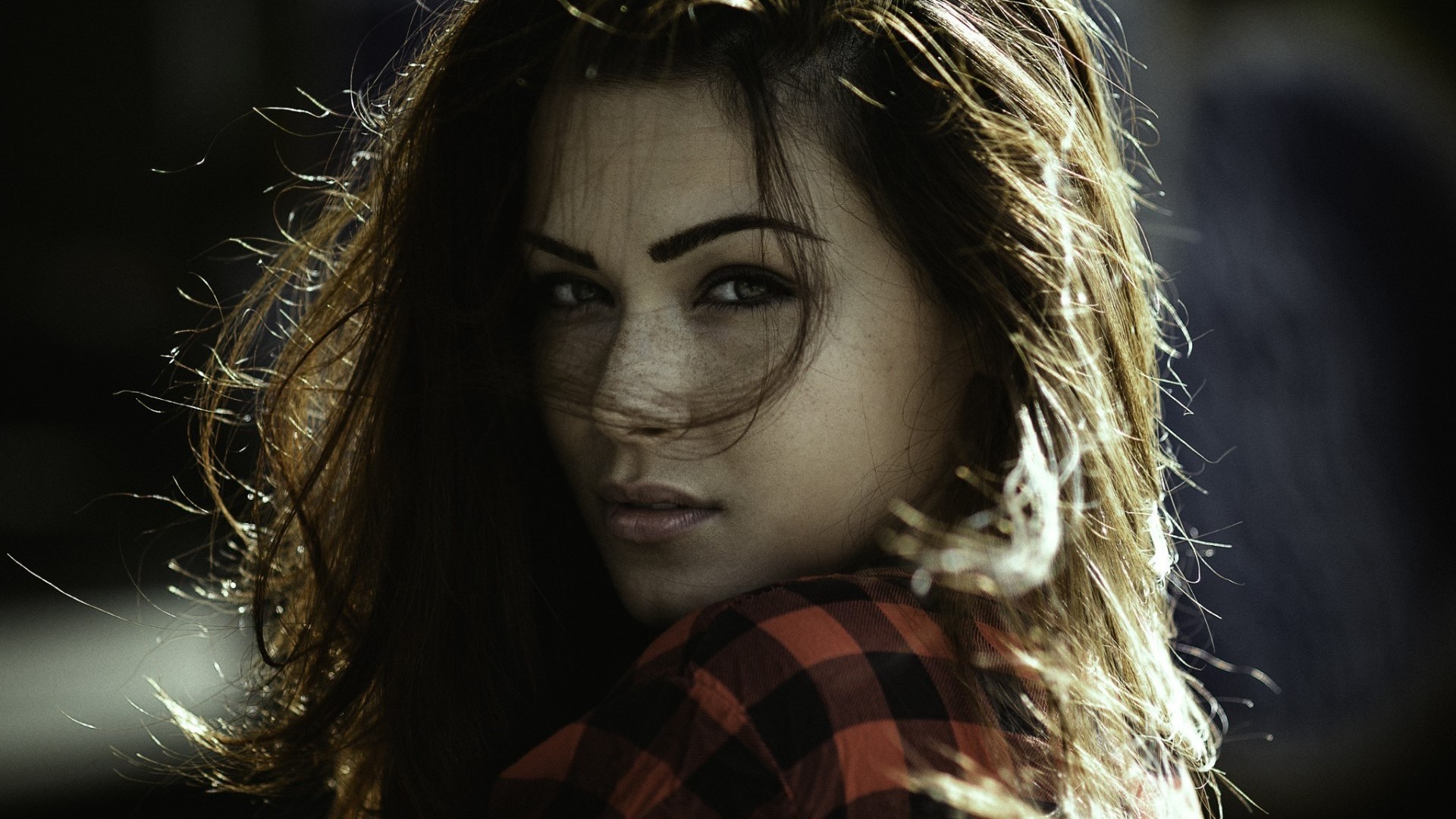 Woman with freckles and windswept hair wearing a plaid shirt HD Wallpaper