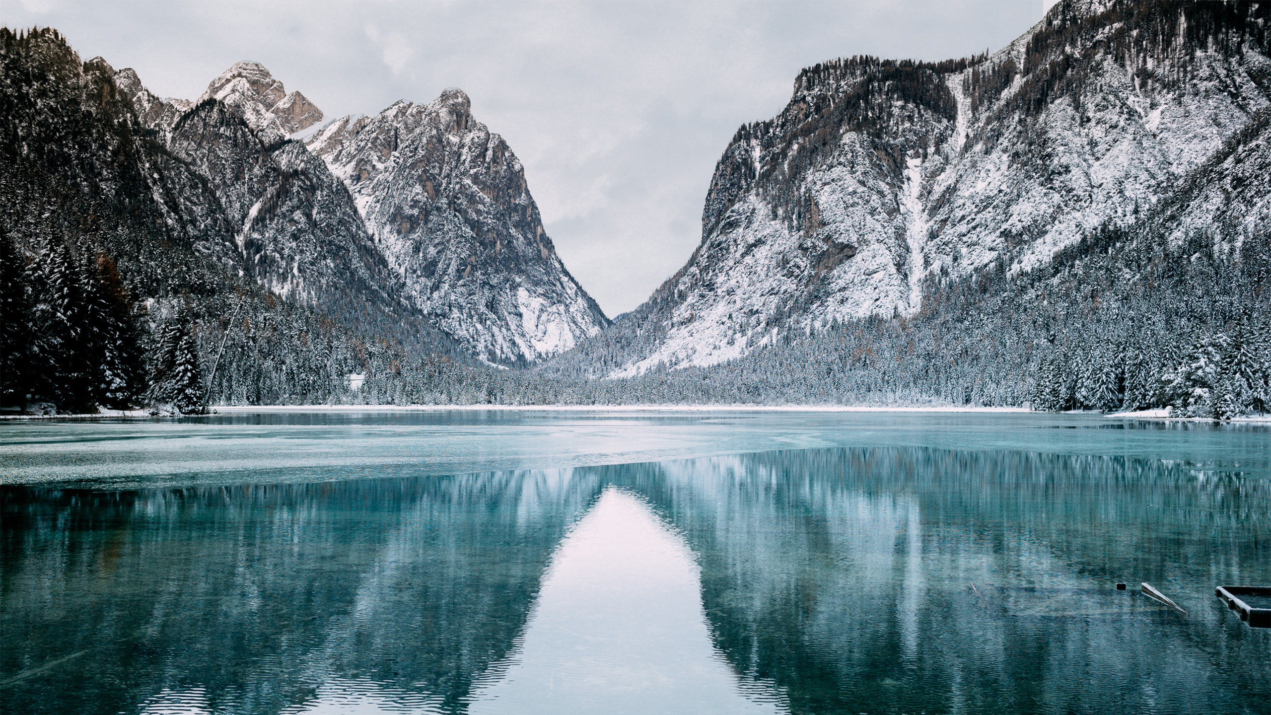 Snowy mountains reflected in a frozen lake in Italy HD Wallpaper
