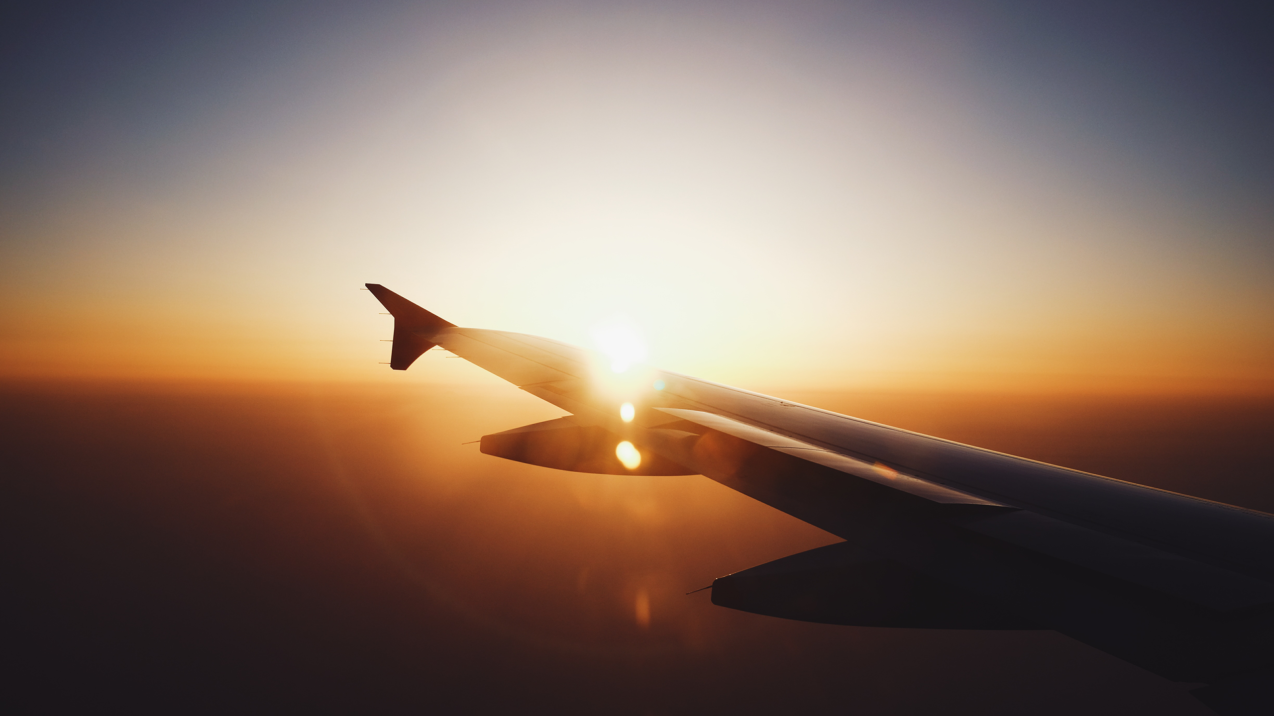 Airplane wing at sunset with lens flare HD Wallpaper