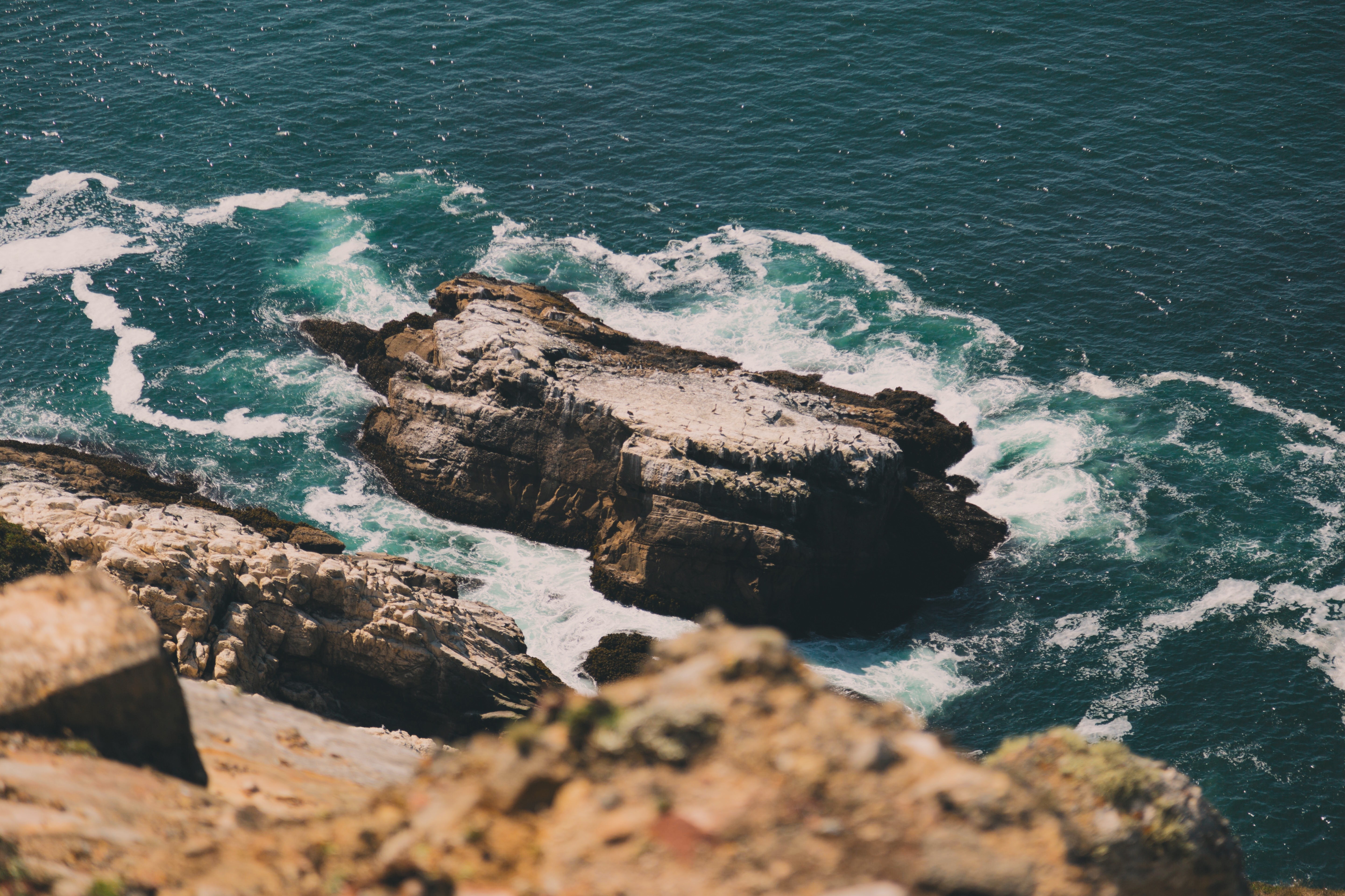Rocky coastline with waves crashing against rocks HD Wallpaper