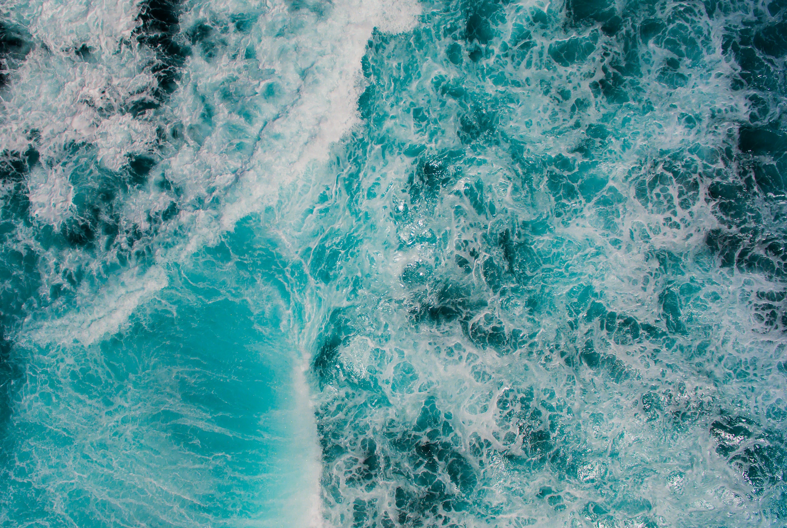 Aerial view of turquoise ocean waves crashing and churning HD Wallpaper