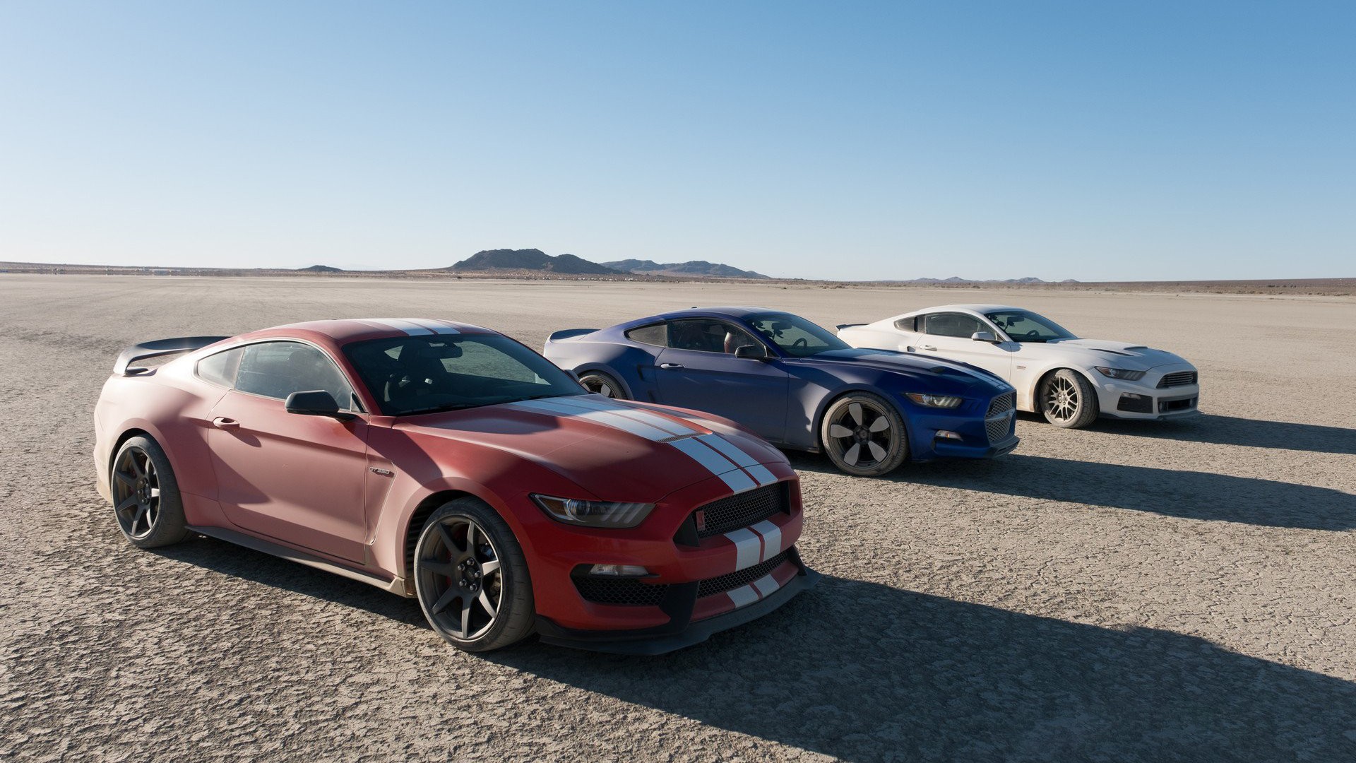 Three Ford Mustang GT350R cars on a dry lake bed HD Wallpaper