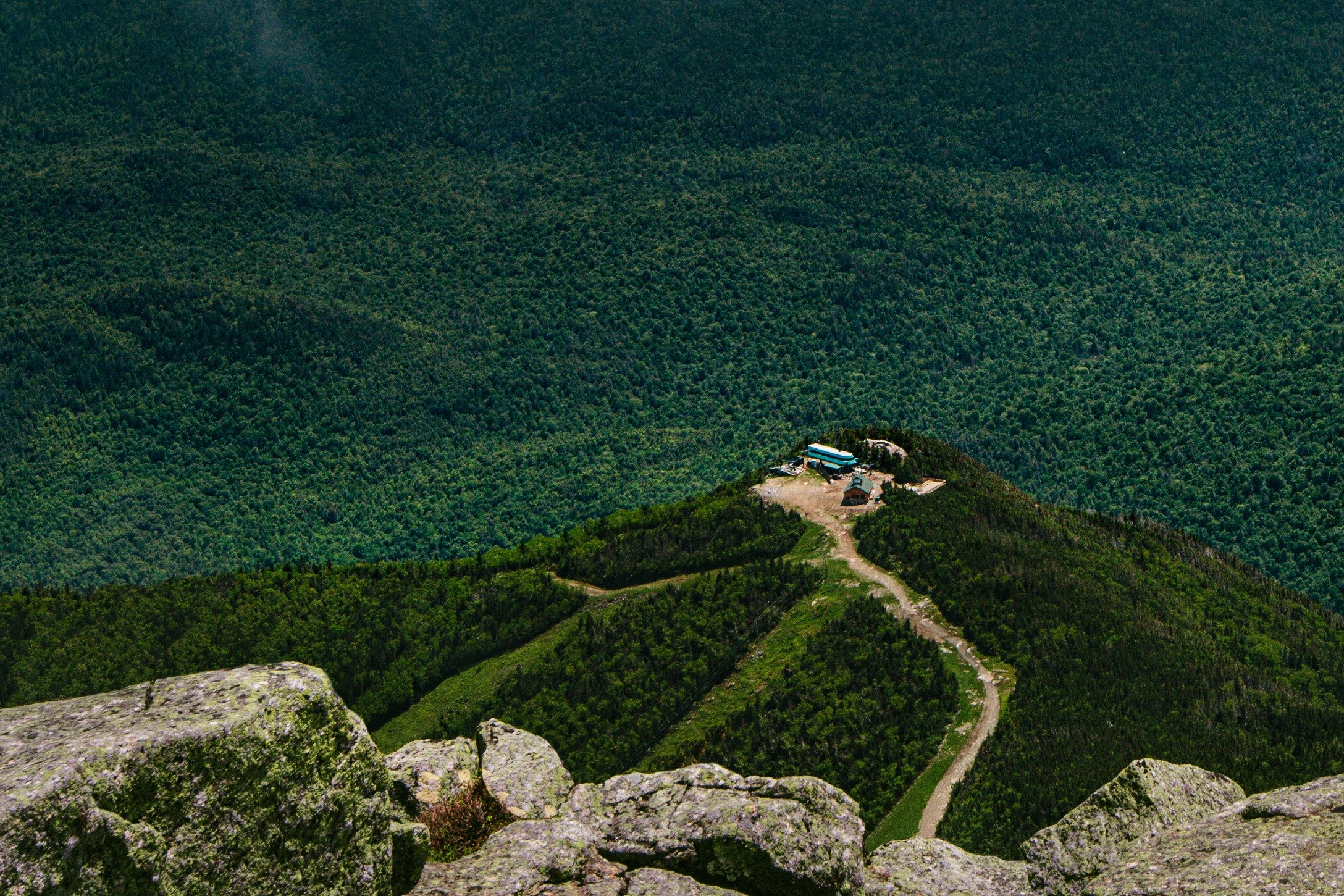 Mountain summit with buildings and forest HD Wallpaper