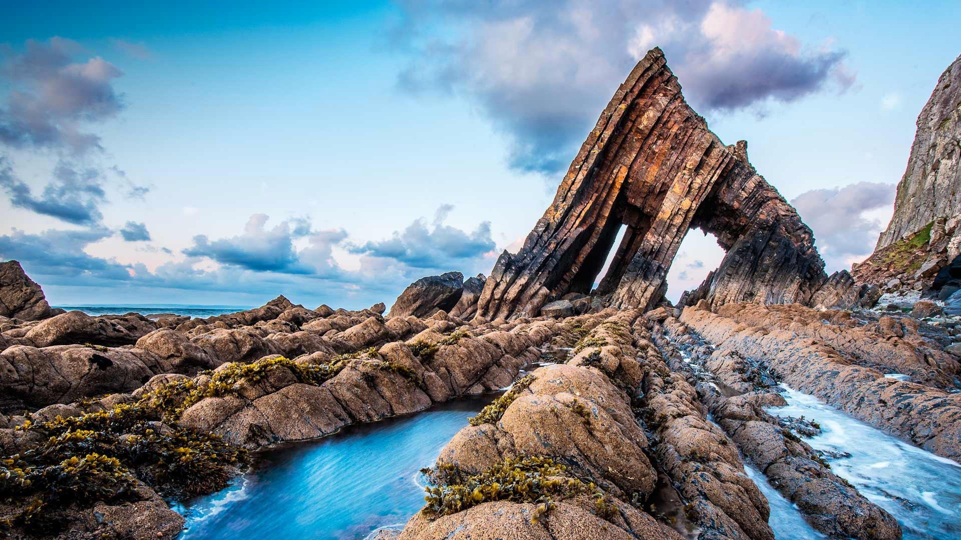 Blackchurch Rock archway on a rocky coastline HD Wallpaper