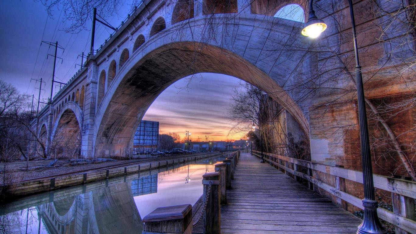 Bridge over canal at sunset with boardwalk and street light HD Wallpaper