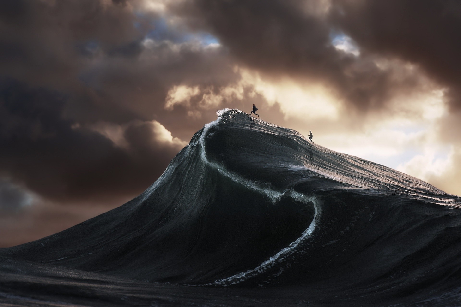 Two surfers riding a massive wave under a stormy sky HD Wallpaper