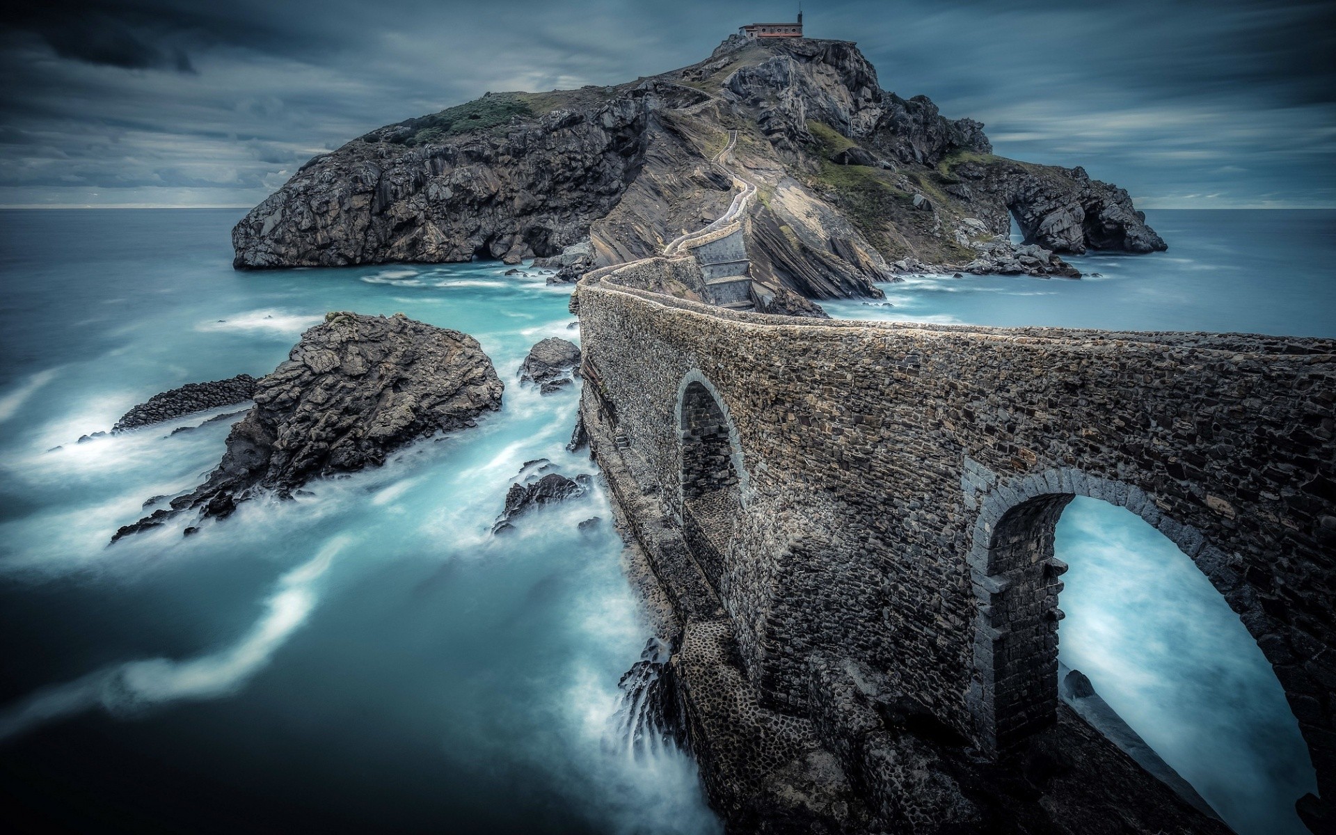San Juan de Gaztelugatxe island with stone bridge in Spain HD Wallpaper