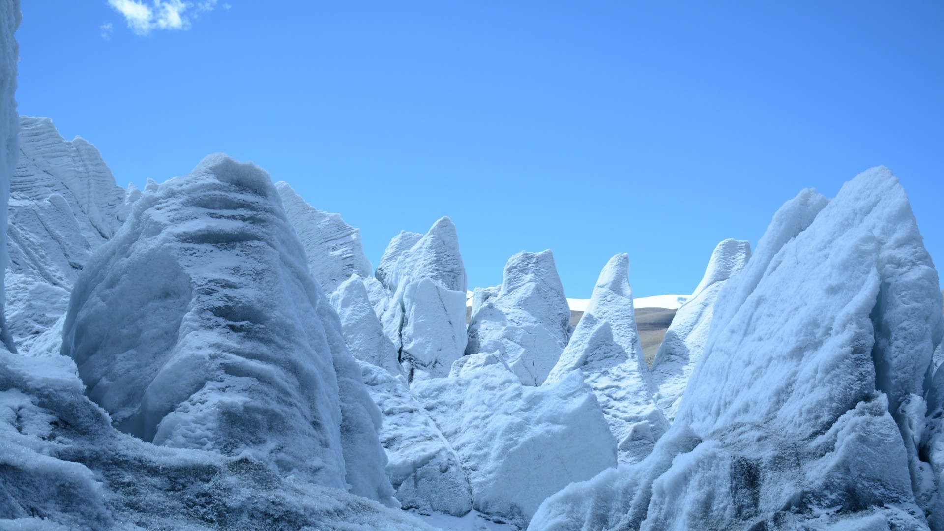 Jagged ice formations under a clear blue sky HD Wallpaper