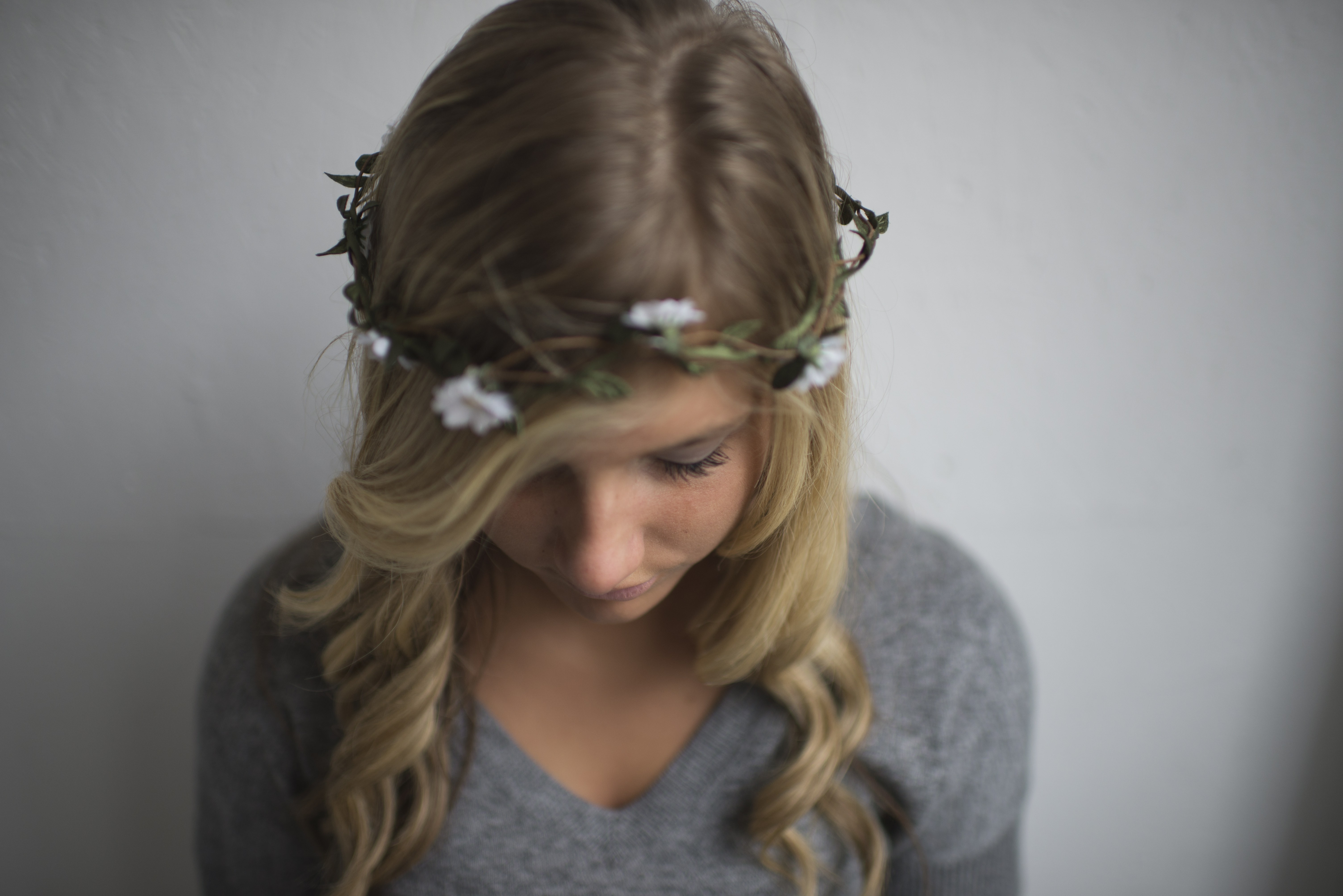 Woman with blonde hair and flower crown looking down HD Wallpaper