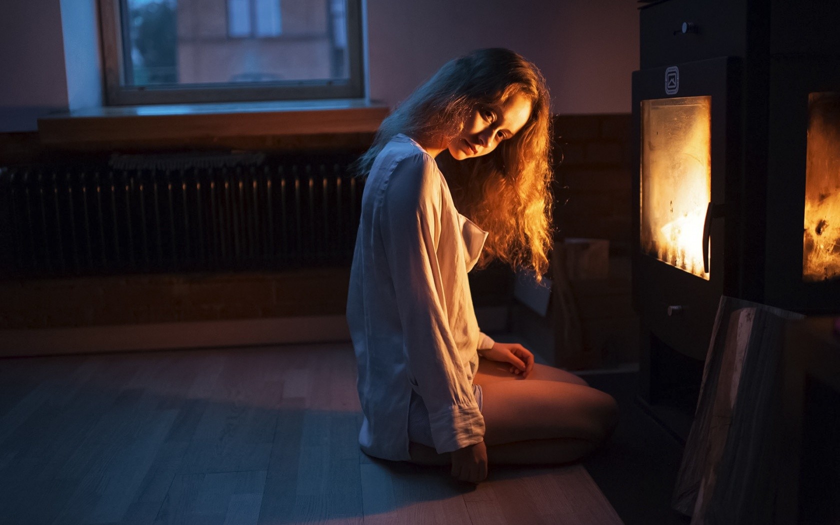 Woman sitting by a fireplace HD Wallpaper