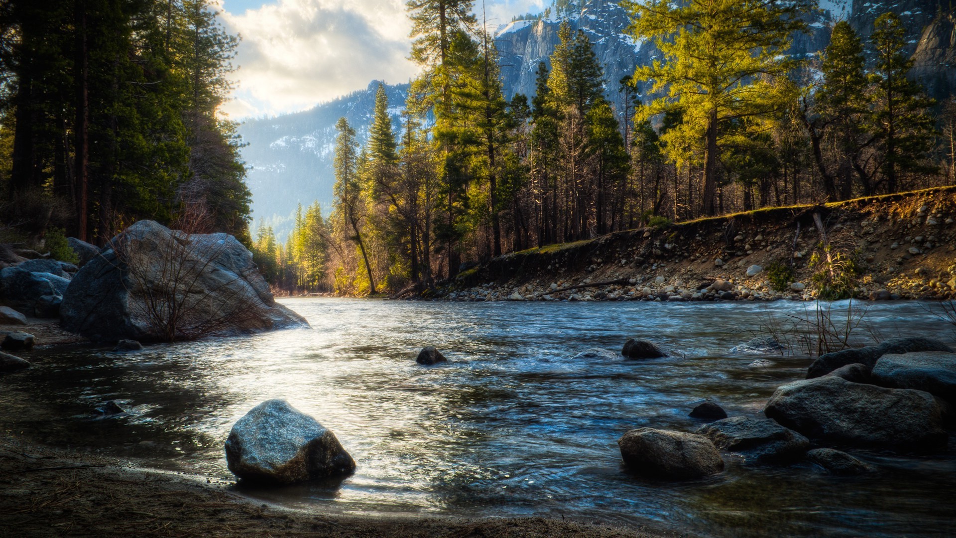 River flowing through a forest with mountains in the background HD Wallpaper