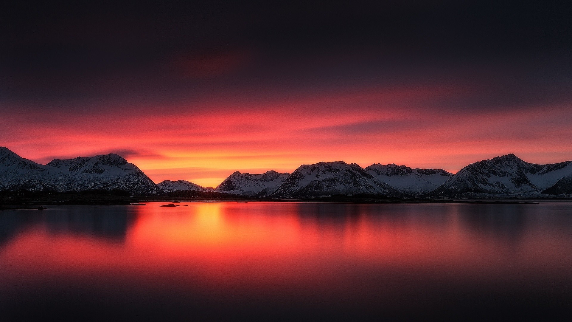 Snowy mountains reflected in a lake at sunset HD Wallpaper