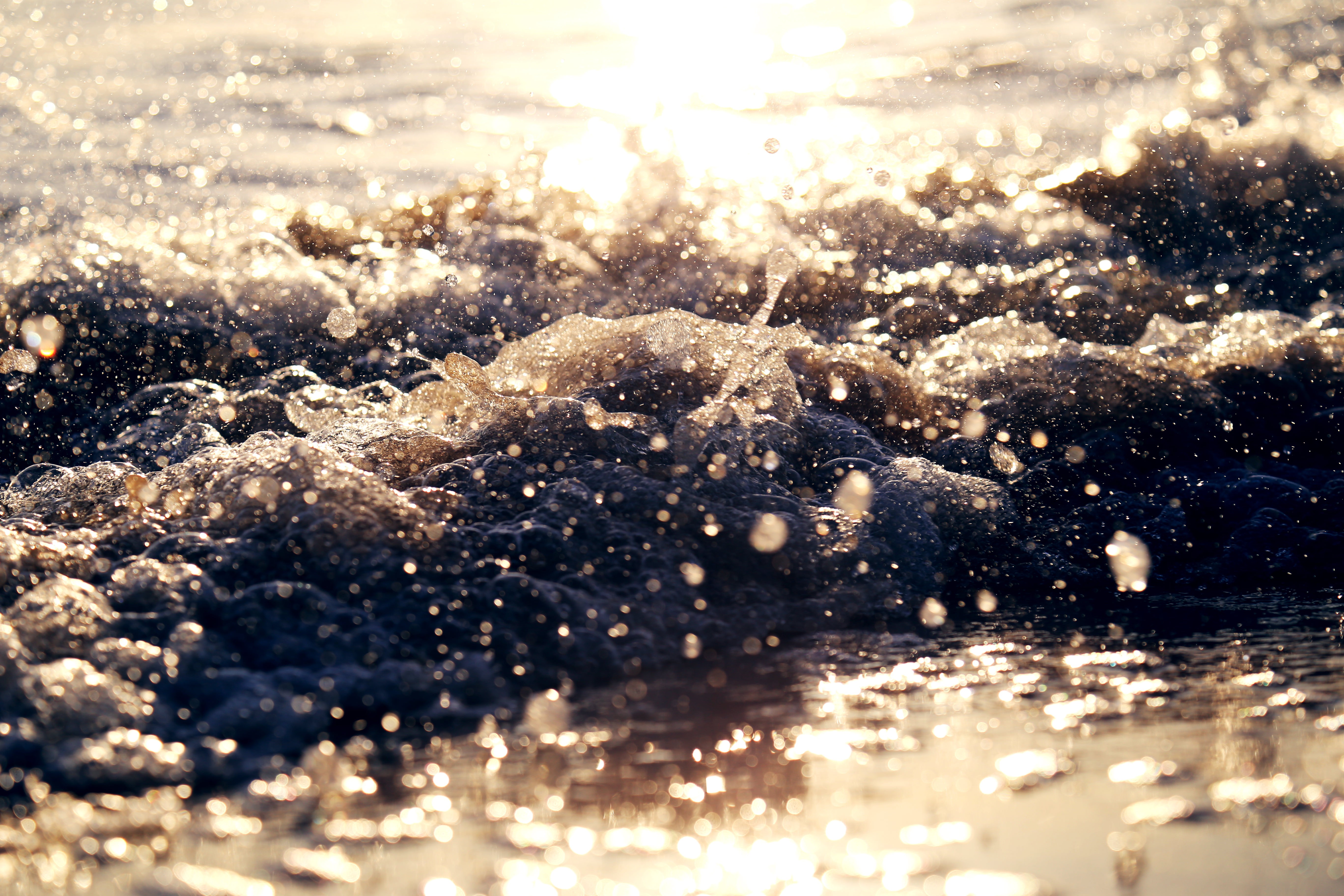 Sunlight on ocean waves crashing on a beach HD Wallpaper