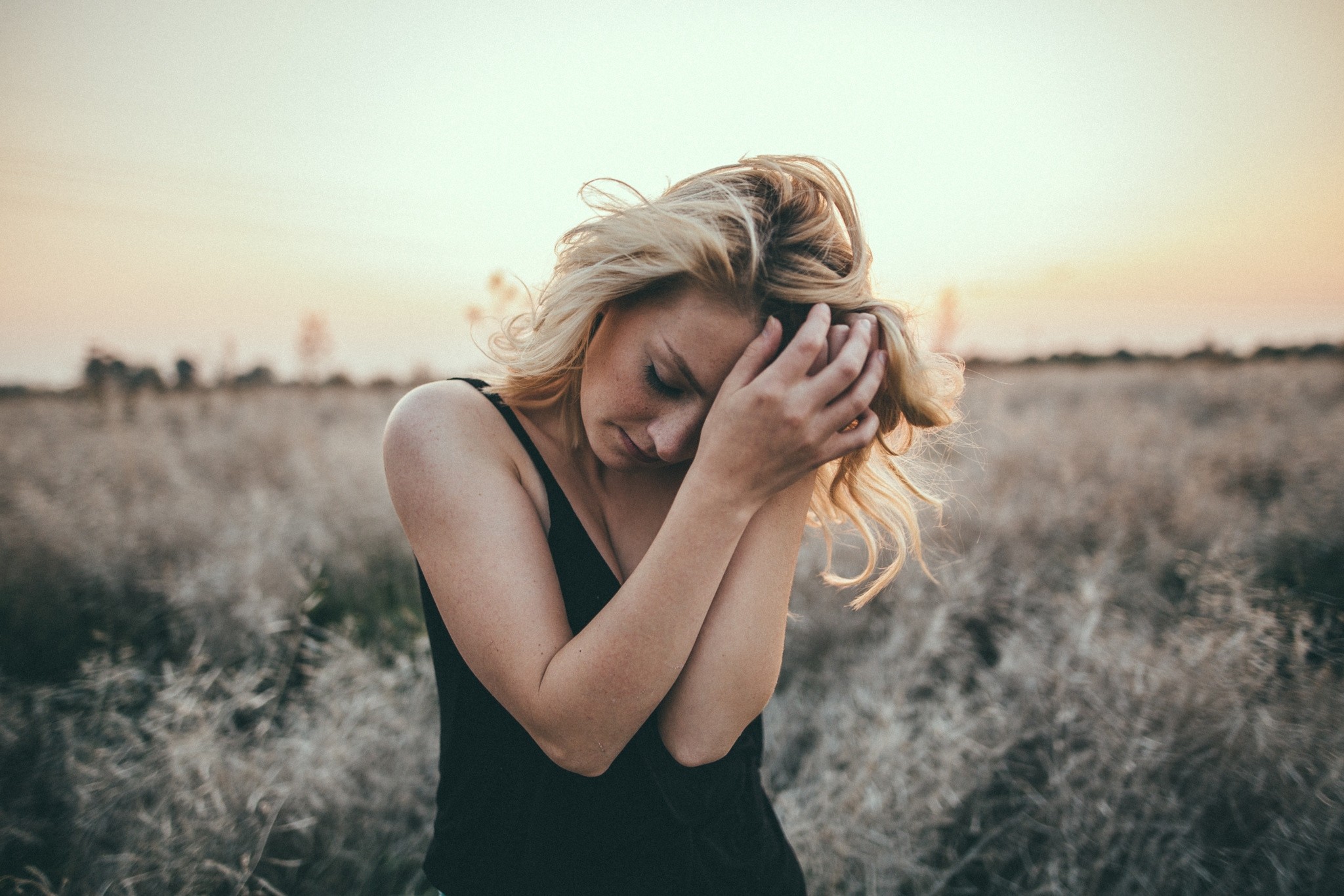 Woman with blonde hair in a field at sunset HD Wallpaper