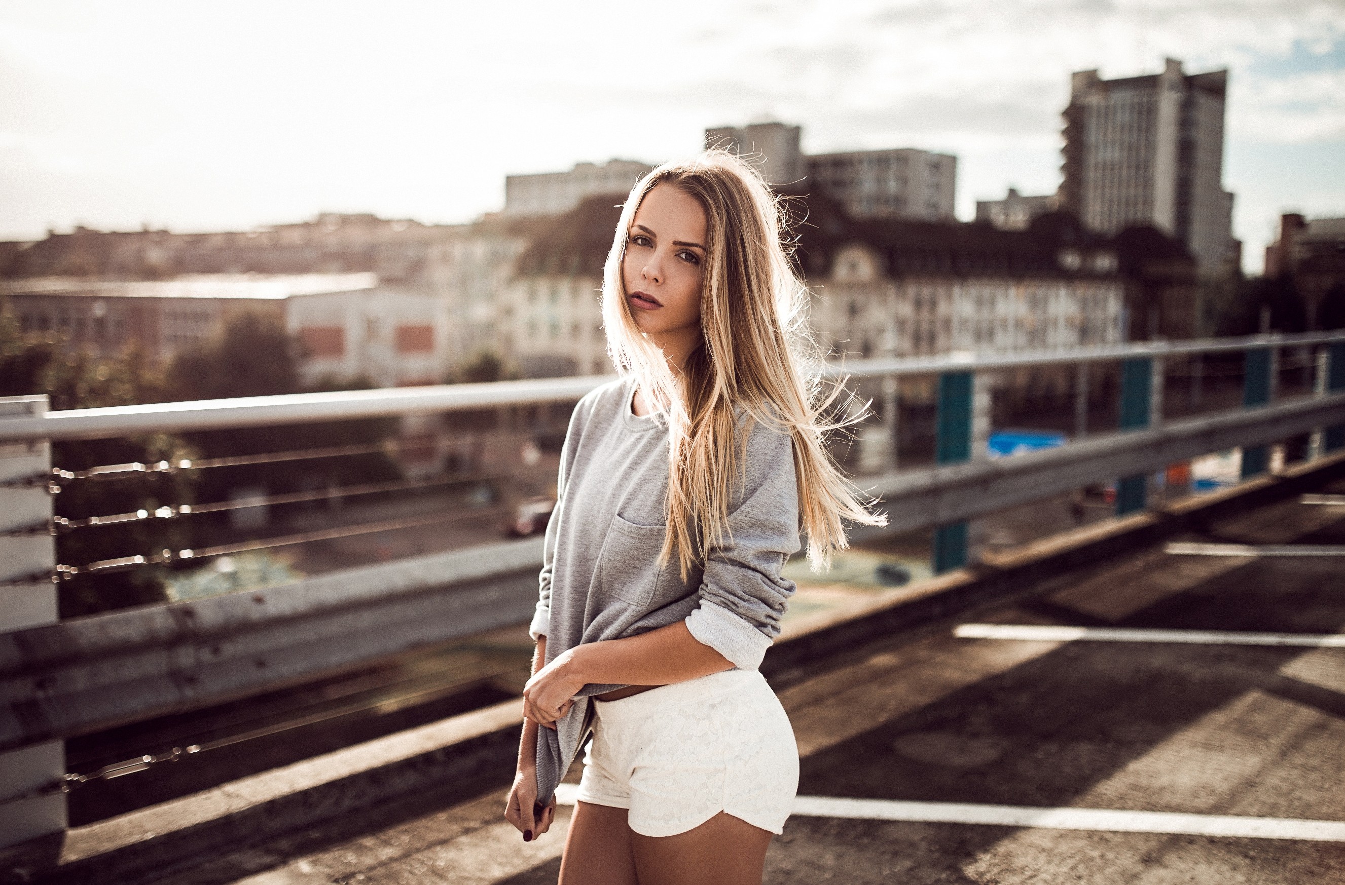 Woman in grey sweatshirt and white shorts on a bridge HD Wallpaper