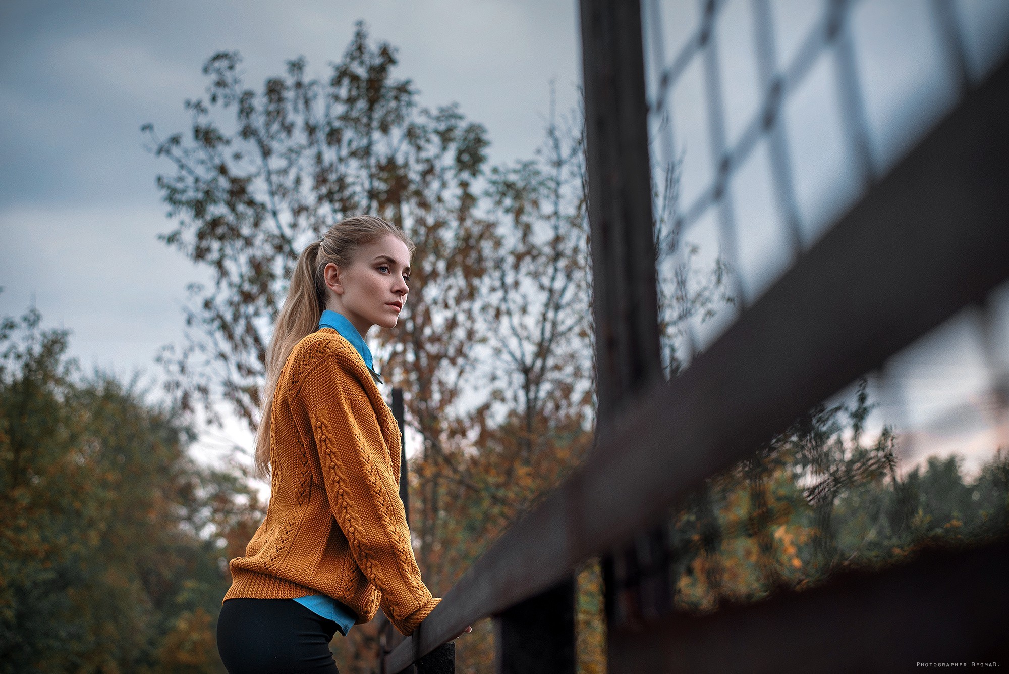 Woman with blonde ponytail wearing a yellow sweater outdoors HD Wallpaper