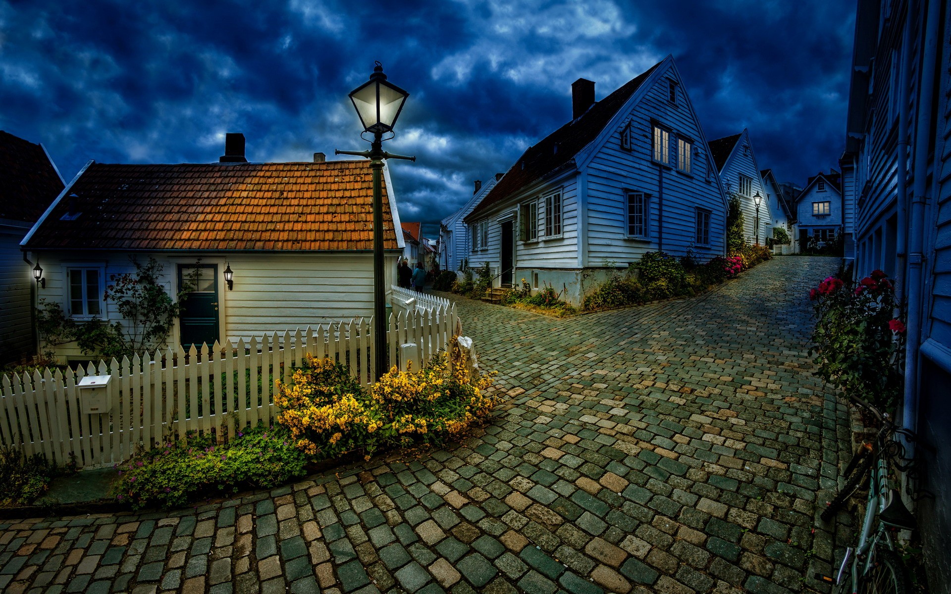 Street light on a cobblestone street in a Norwegian village at night HD Wallpaper