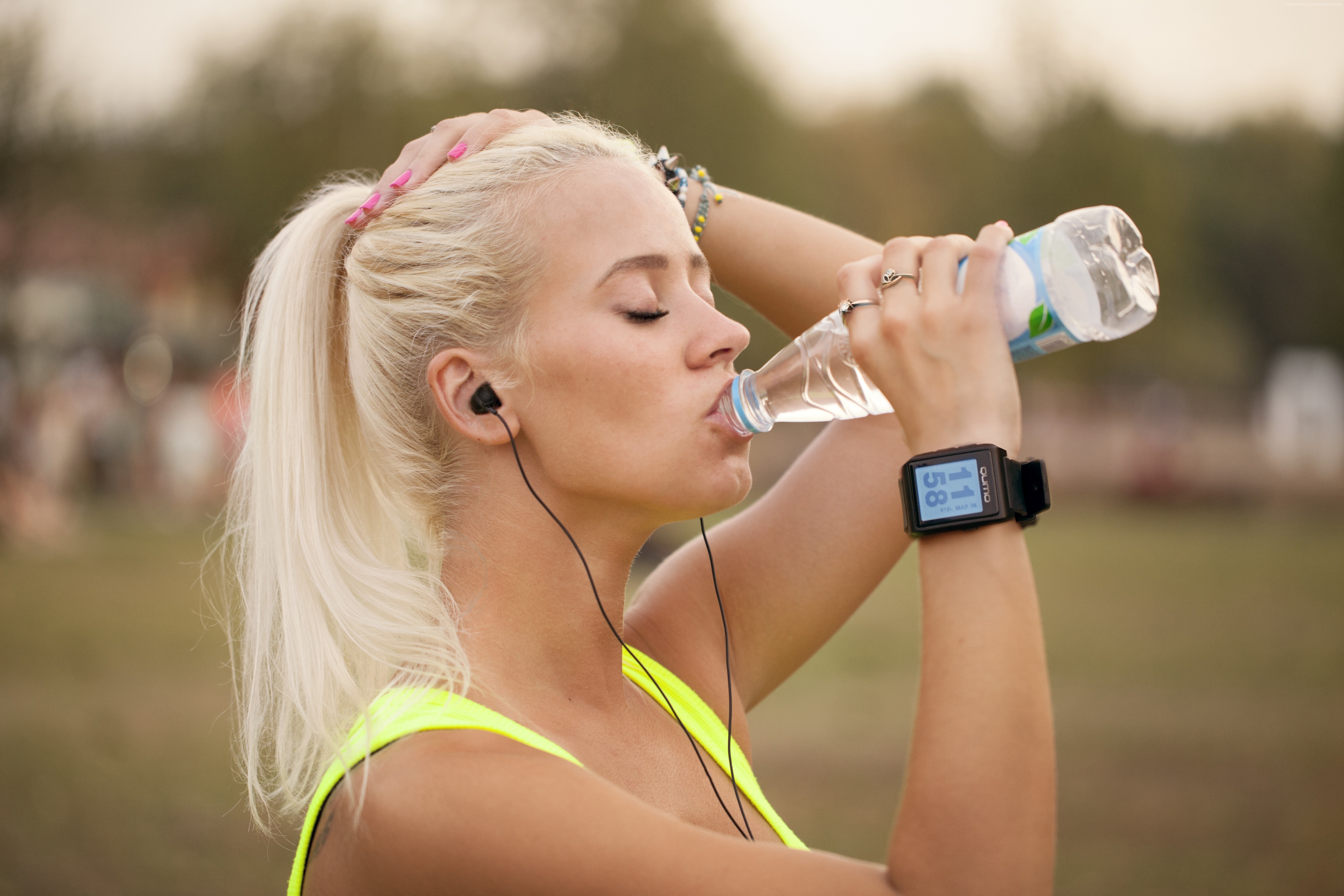 Woman in yellow clothing drinking water with QUMO watch HD Wallpaper