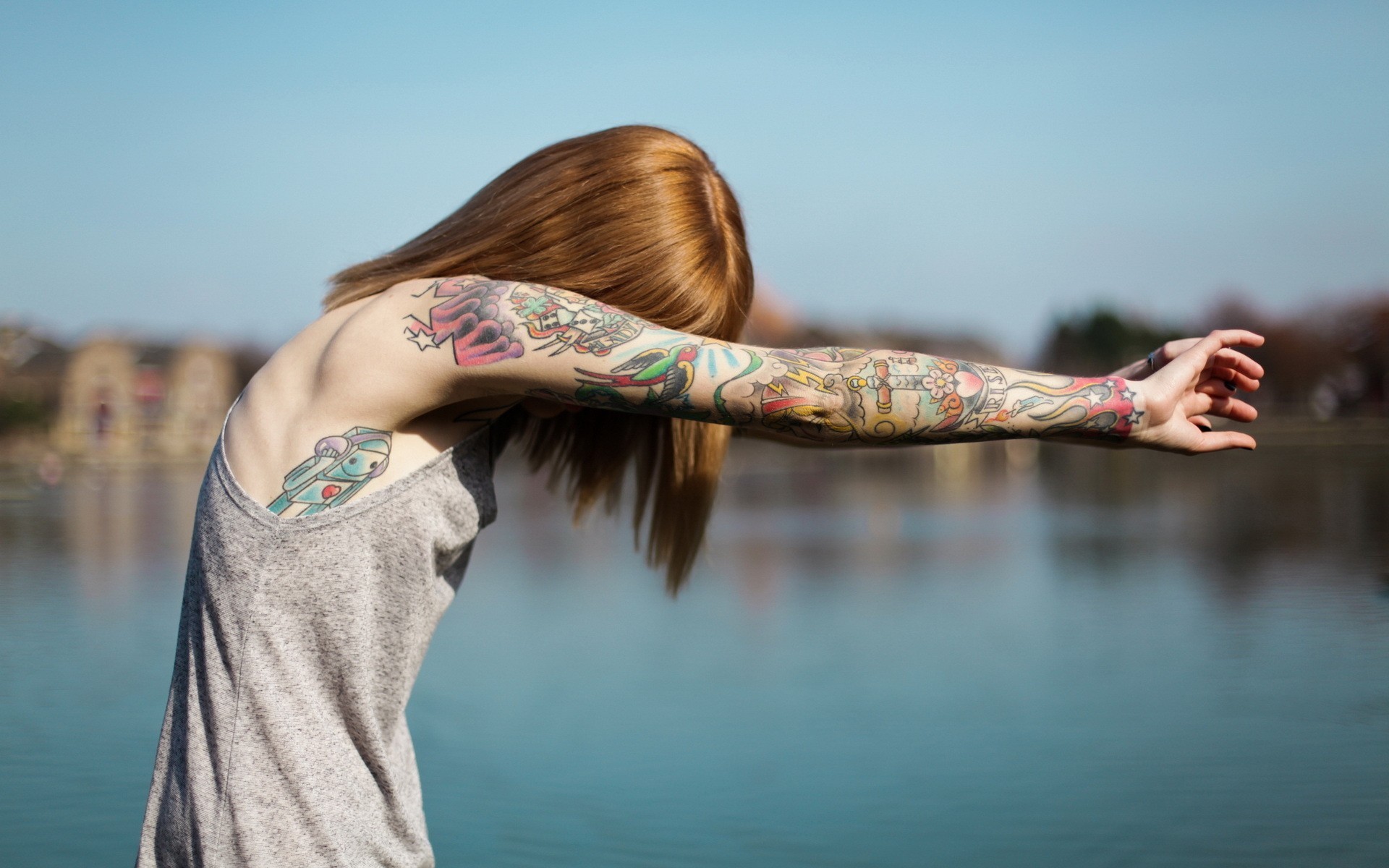 Woman with full sleeve tattoos by the water HD Wallpaper