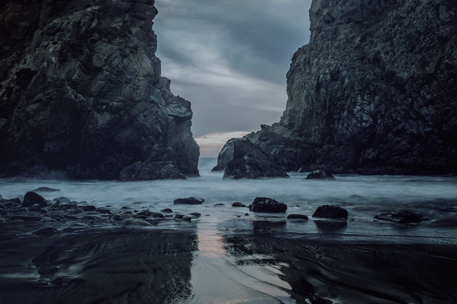 Dark rocky sea stacks and beach at dusk HD Wallpaper