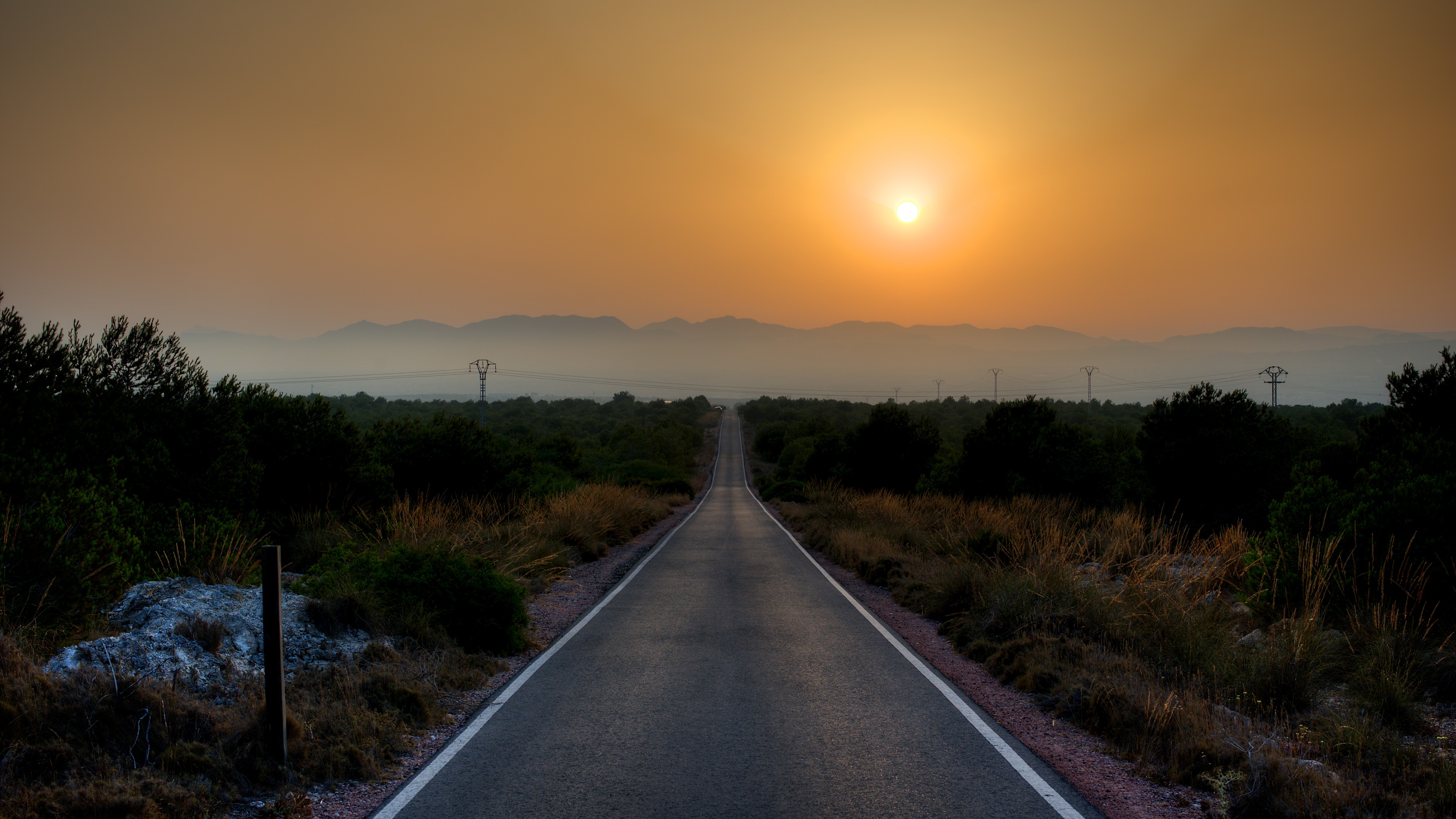 Road leading to mountains at sunset HD Wallpaper