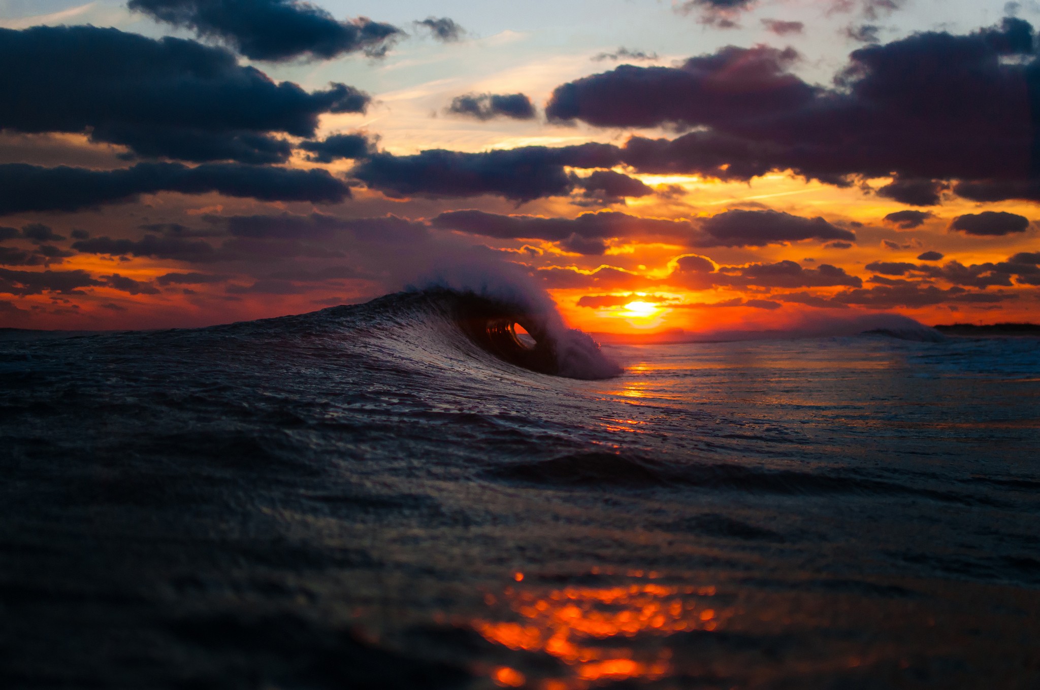Wave crashing at sunset with dramatic clouds HD Wallpaper
