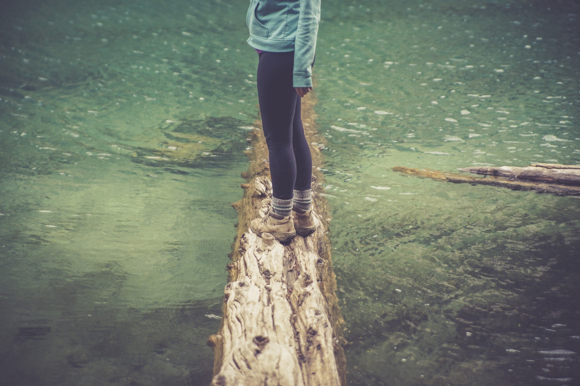 Person balancing on a log over water HD Wallpaper