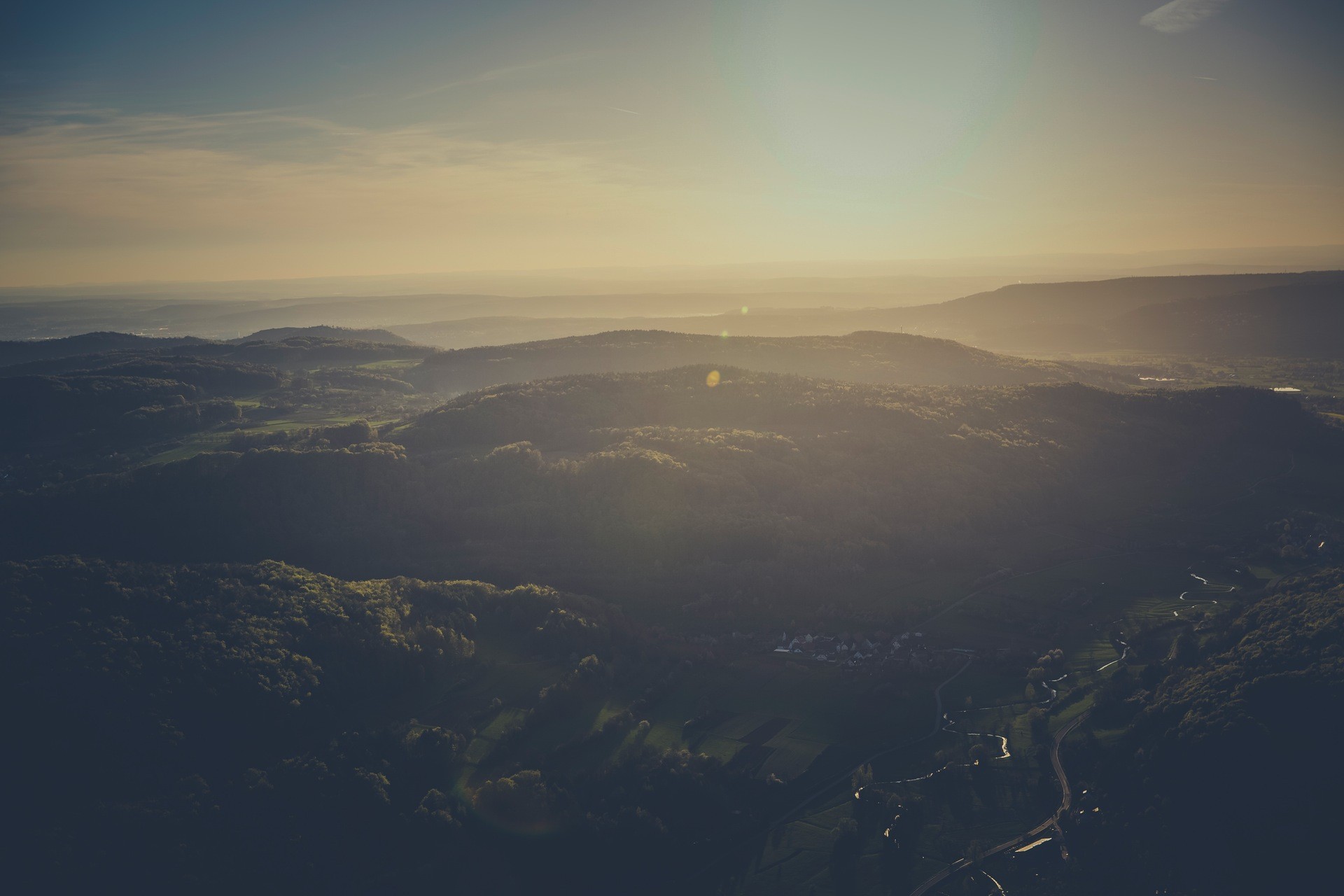 Sunset over rolling hills and forests HD Wallpaper