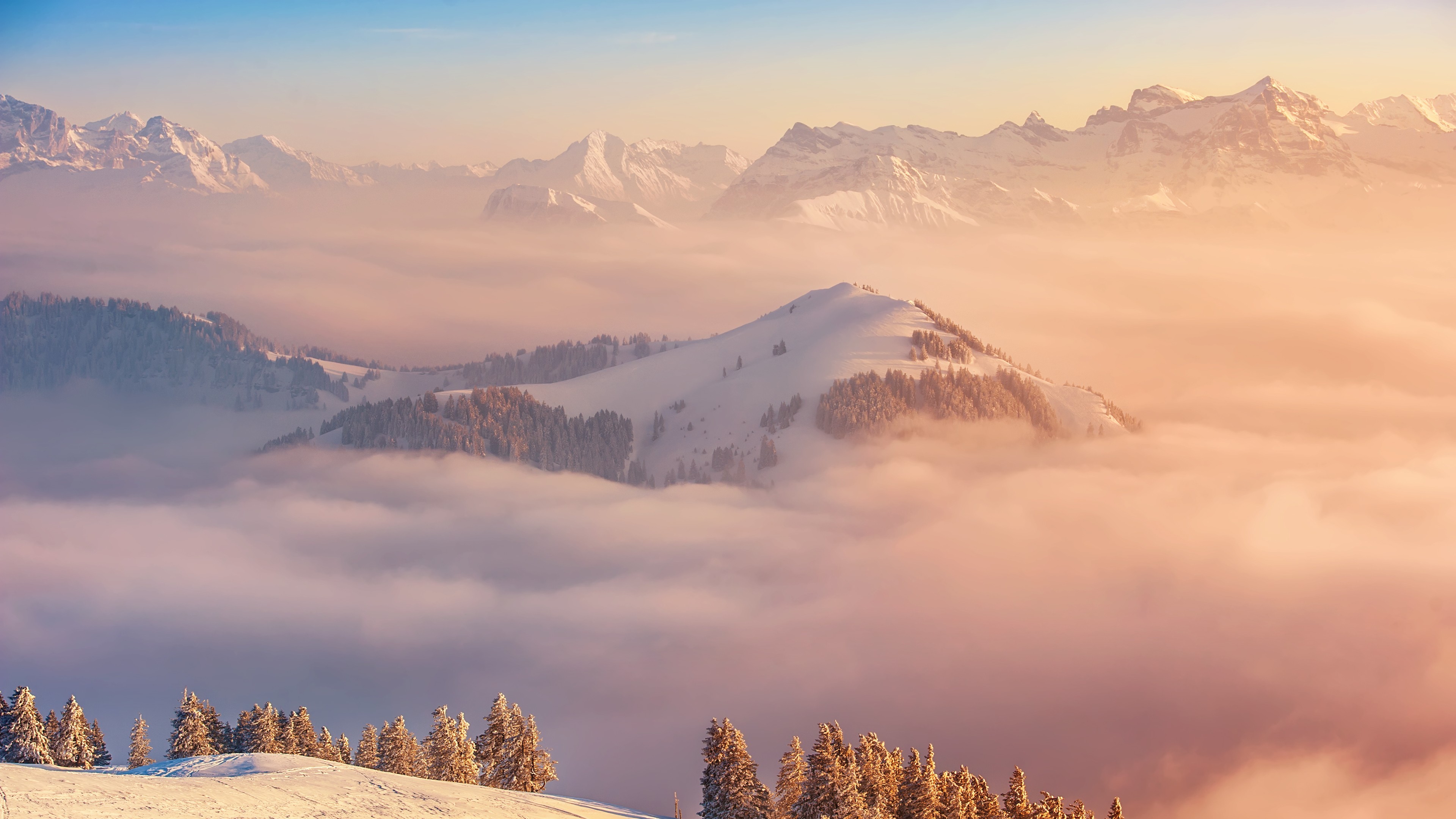 Snowy mountains above clouds at sunrise HD Wallpaper