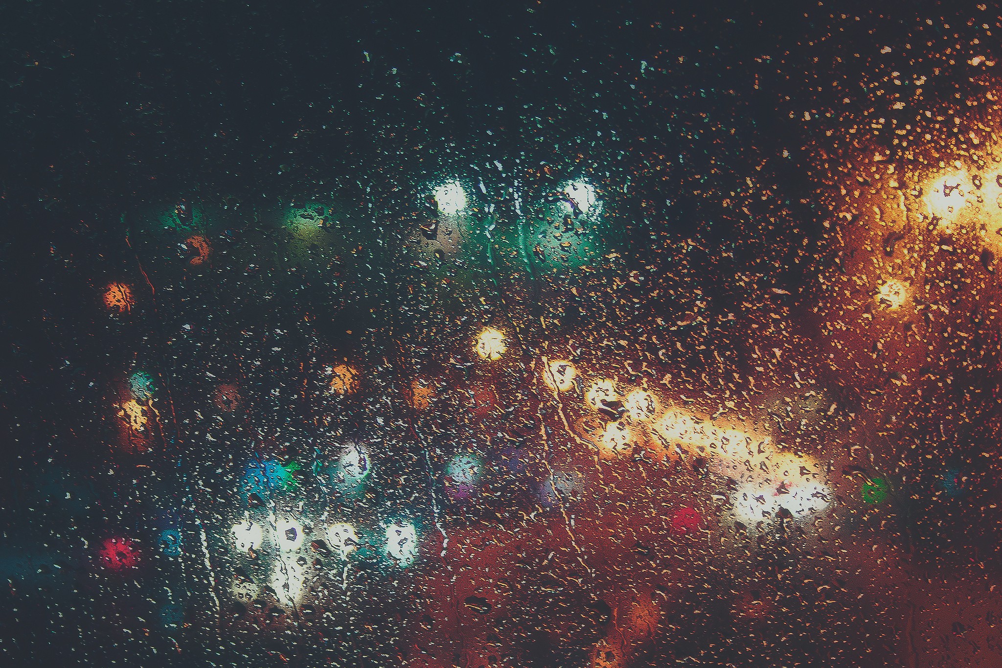 Rainy window with blurred city lights at night HD Wallpaper