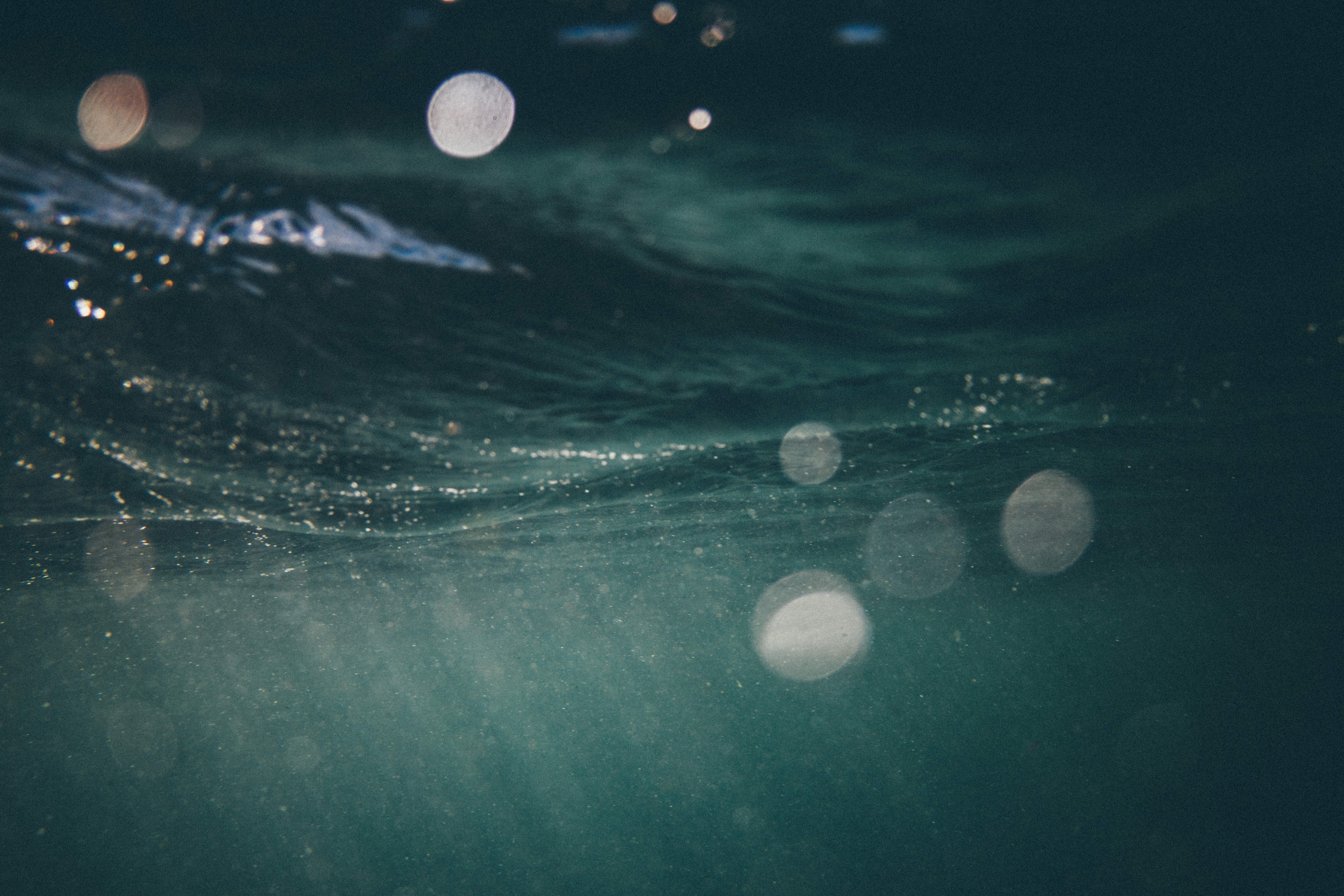 Underwater view of dark blue water with light reflections HD Wallpaper