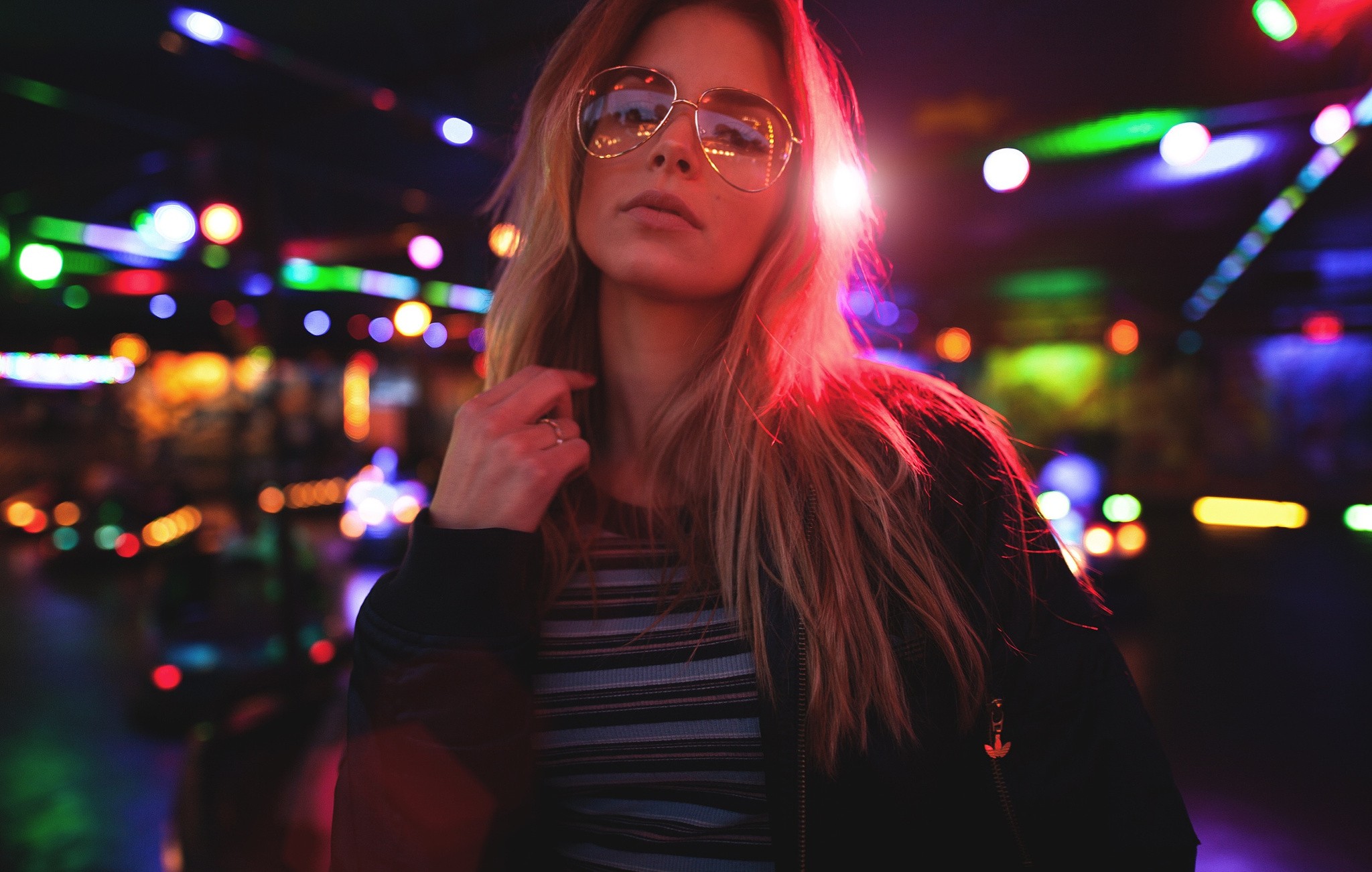 Woman with glasses in front of colorful lights HD Wallpaper