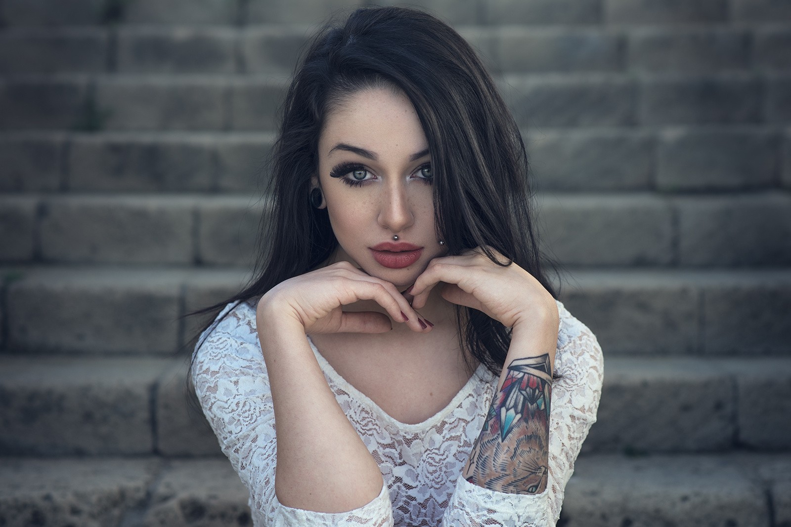 Woman with tattoos and piercings sitting on stairs HD Wallpaper