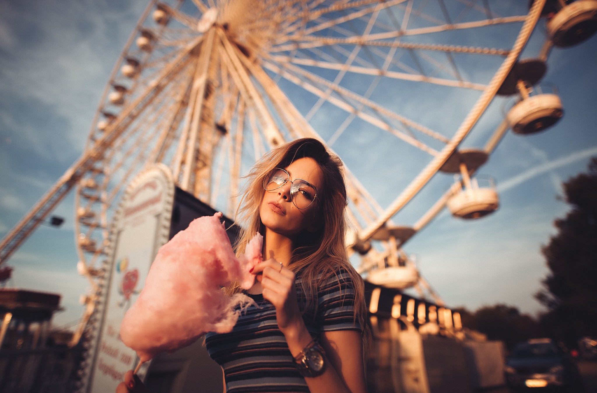 Woman with cotton candy in front of Ferris wheel HD Wallpaper