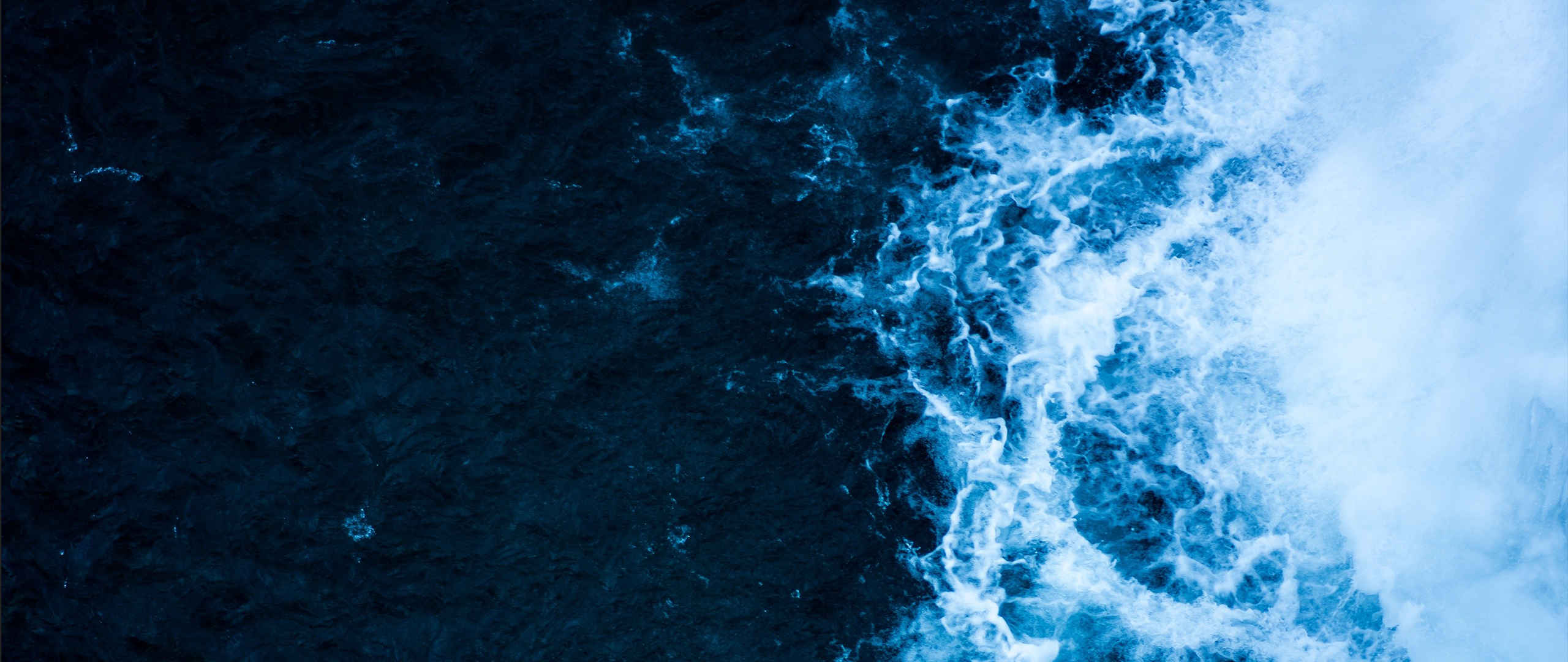 Aerial view of a powerful waterfall with dark blue water HD Wallpaper