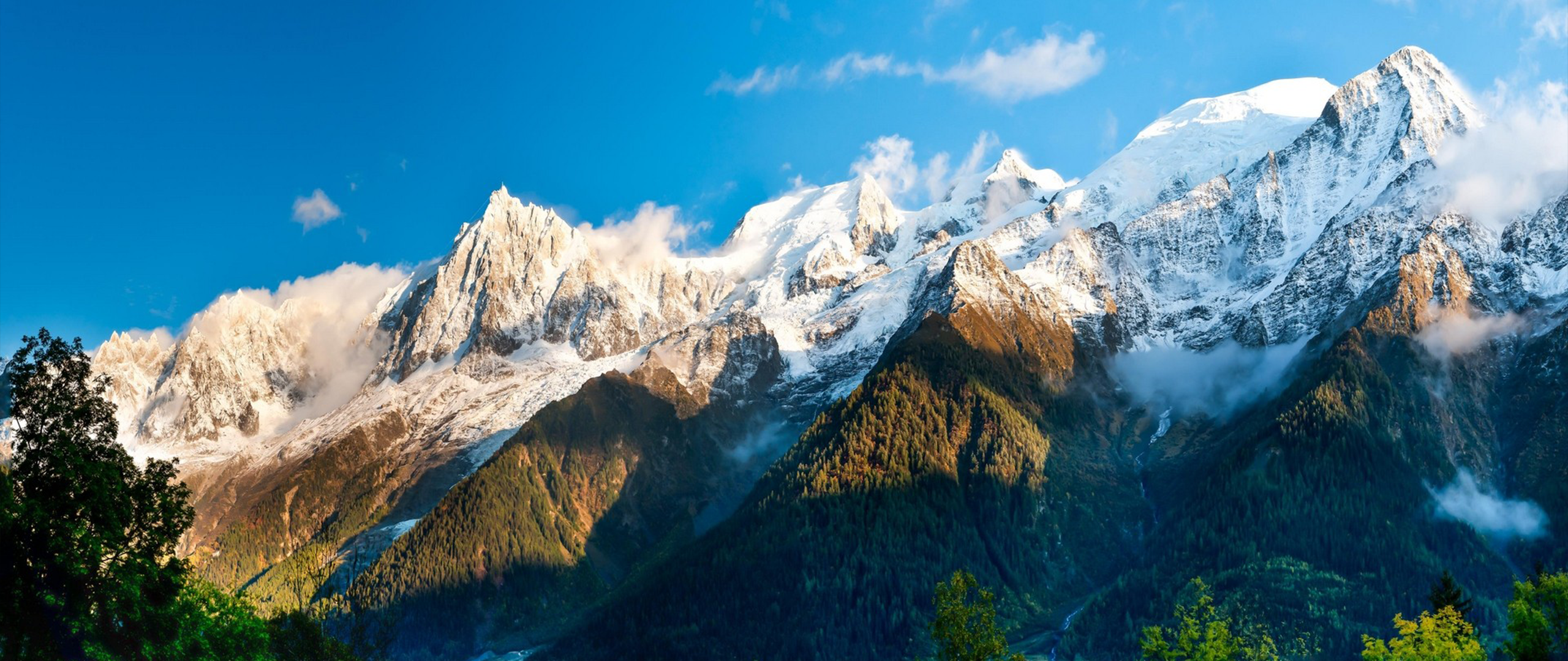Snow-capped mountains under a blue sky HD Wallpaper