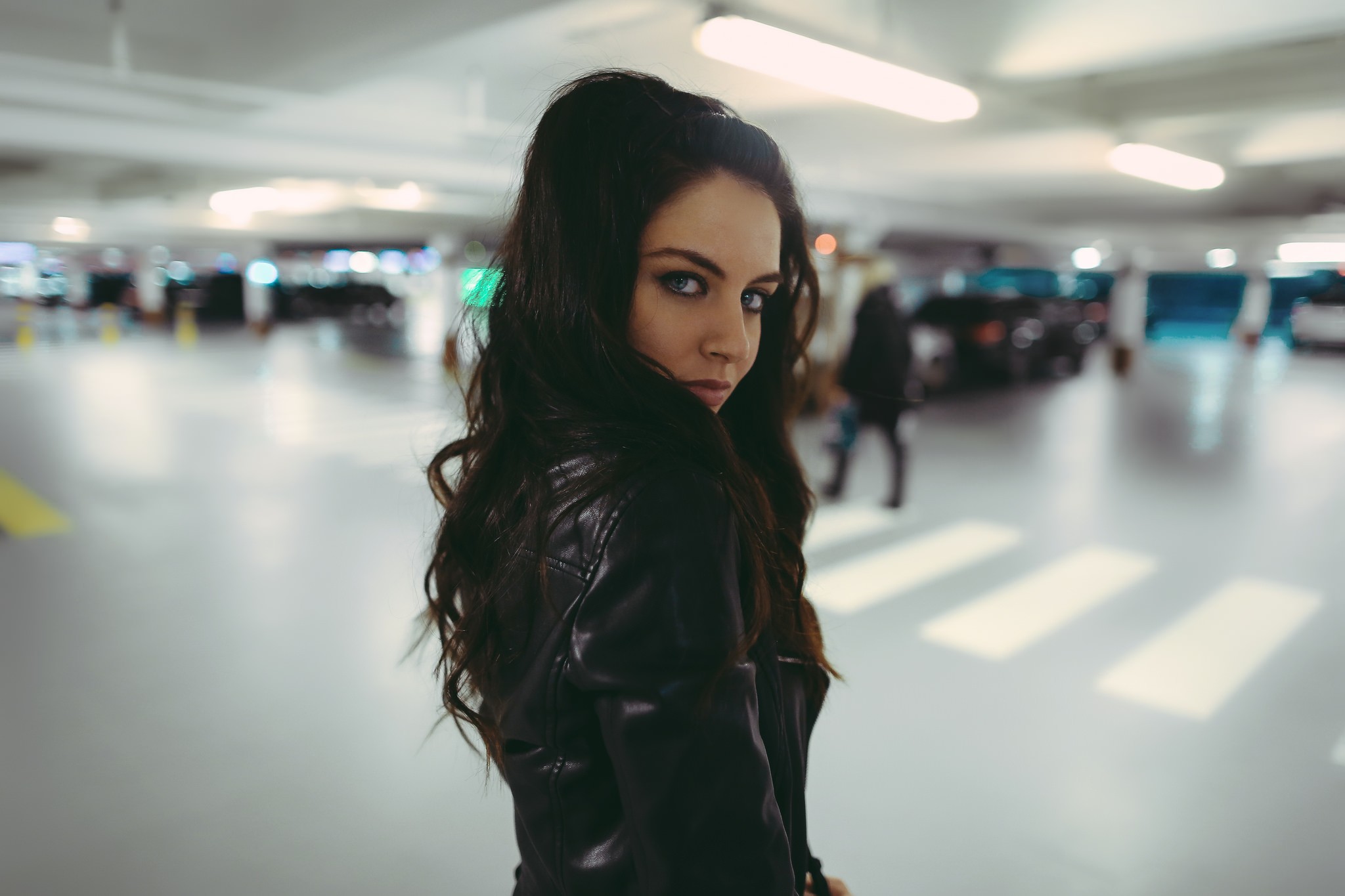 Aurela Skandaj in a parking lot looking over her shoulder HD Wallpaper