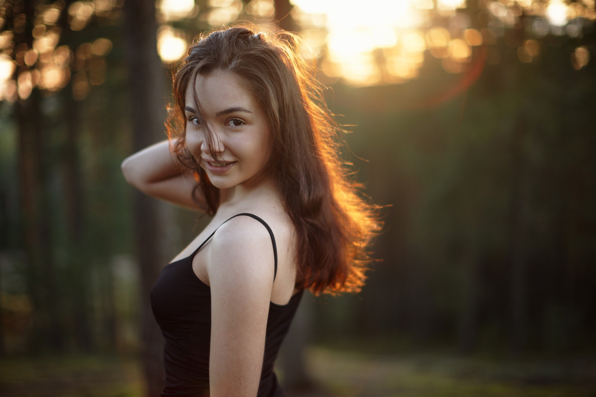 Woman smiling in a forest at sunset HD Wallpaper