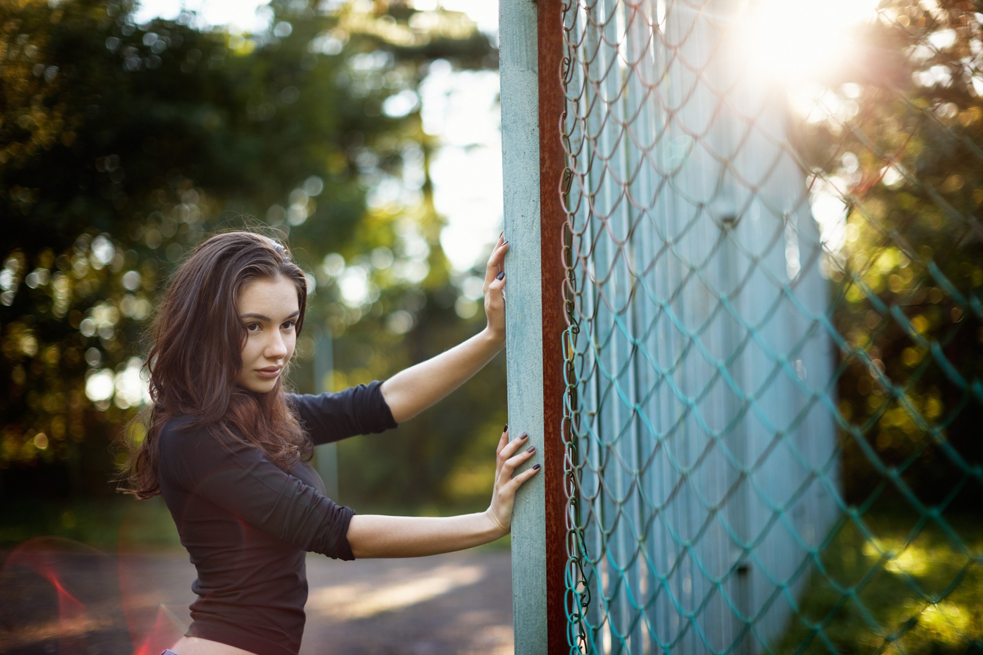 Woman leaning on a fence in sunlight HD Wallpaper