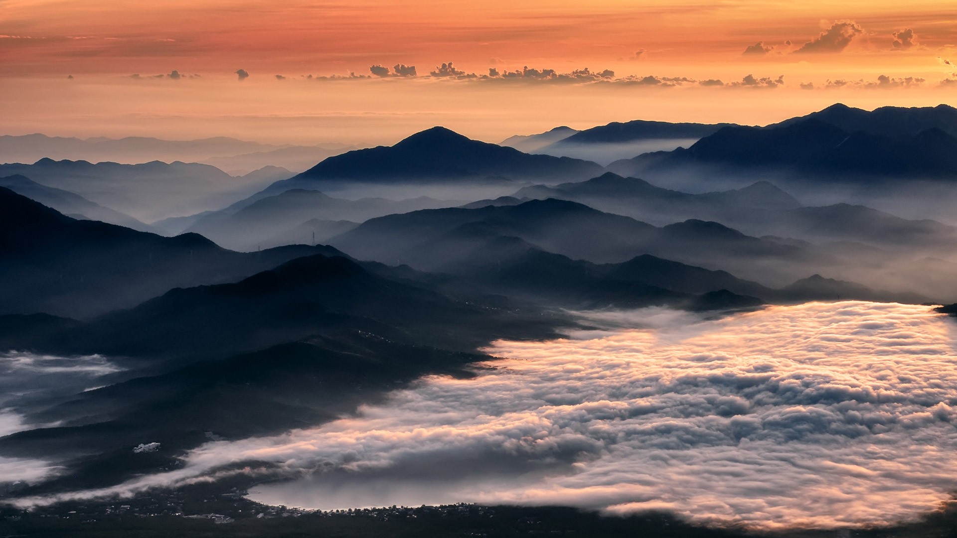 Mountains shrouded in mist at sunrise HD Wallpaper