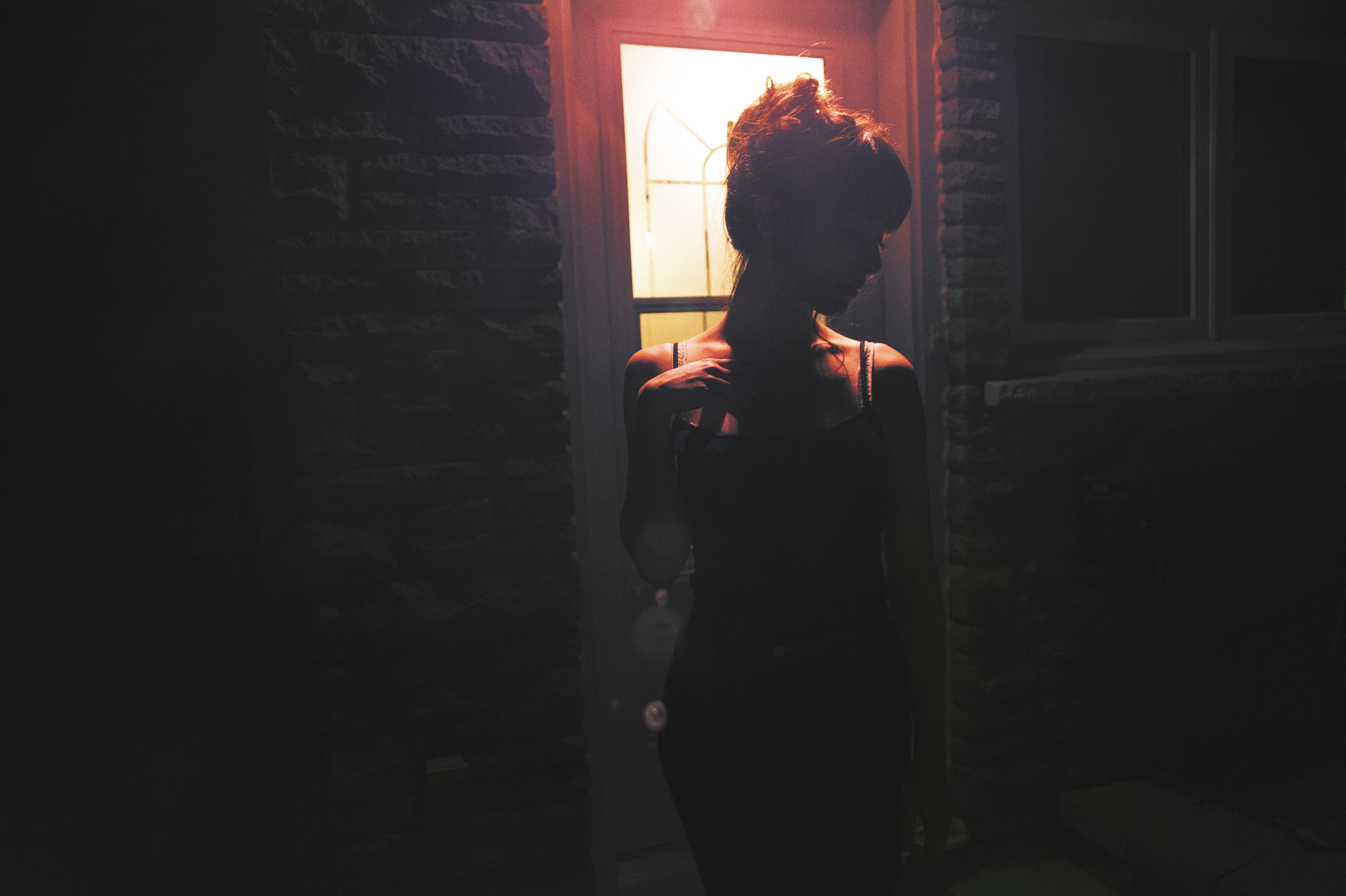 Woman in black tank top standing by a door at night HD Wallpaper
