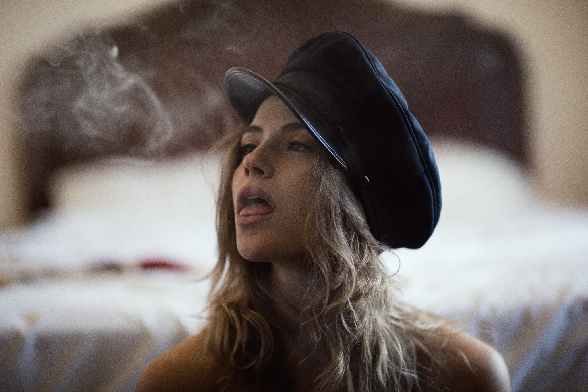 Woman in a black hat with smoke and tongue out HD Wallpaper